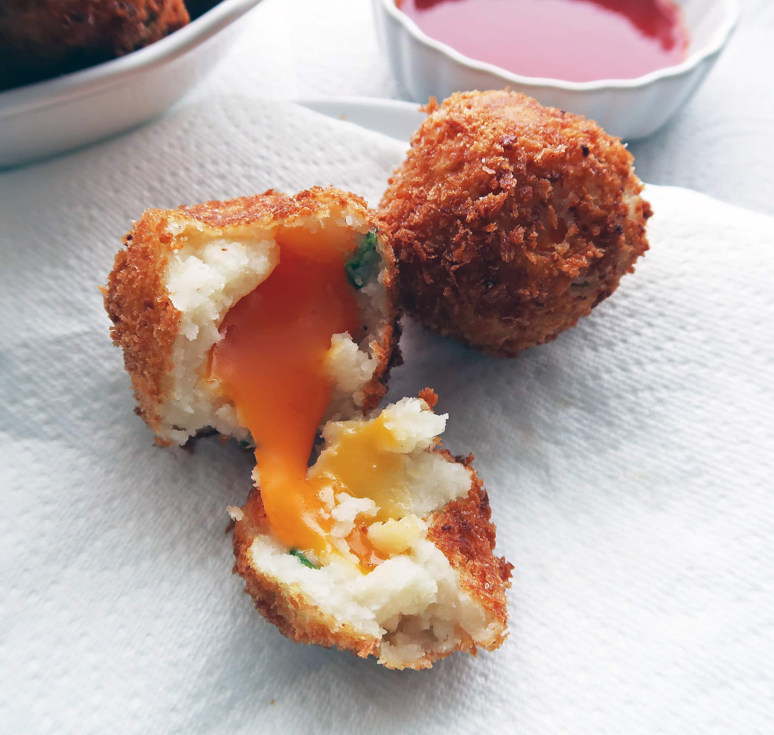 The inside of a crispy mashed potato balls showing melted cheese.