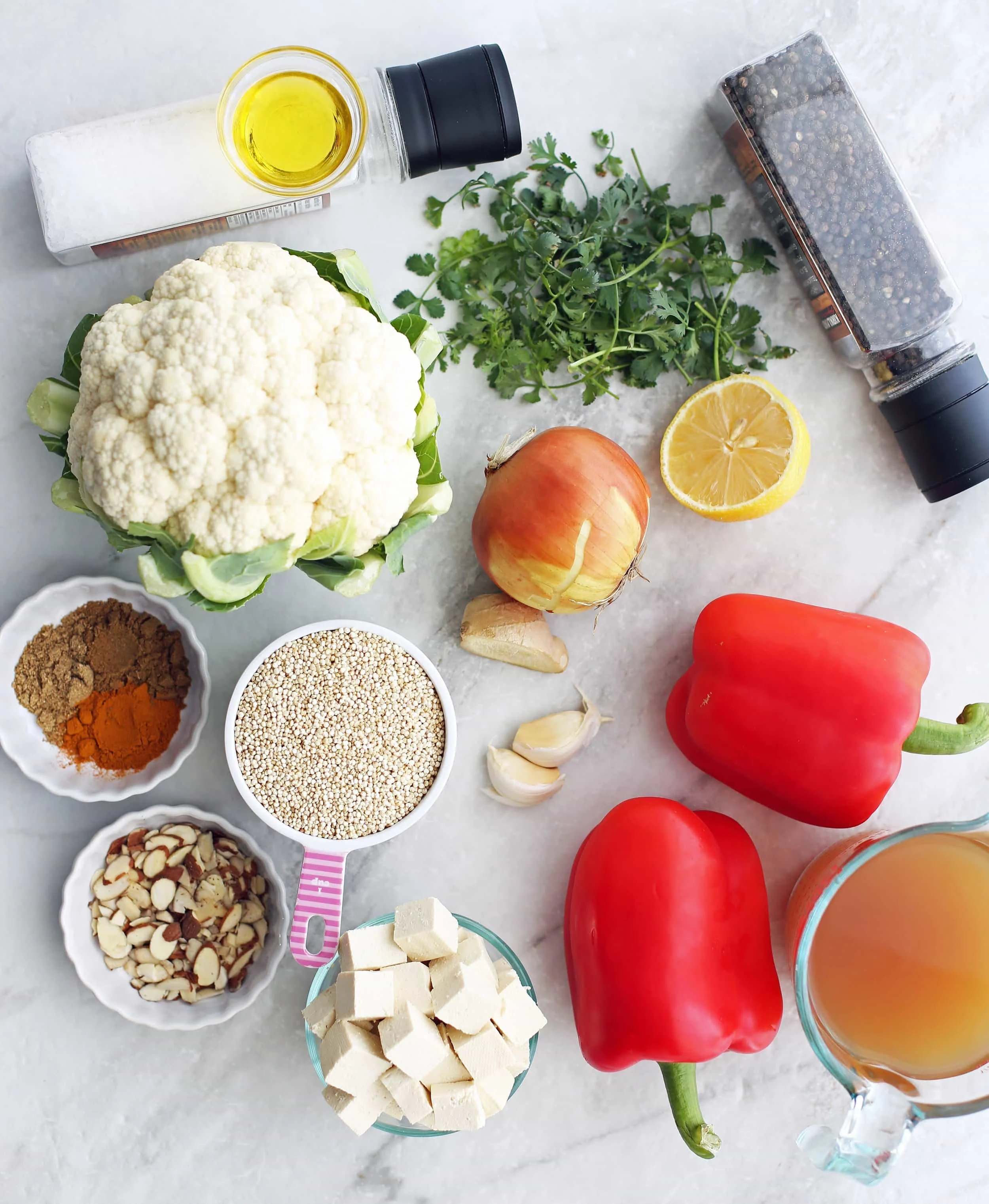 Red bell peppers, tofu, dry quinoa, sliced almonds, cauliflower, onion, lemon, garlic, ginger, cilantro, and vegetable broth.