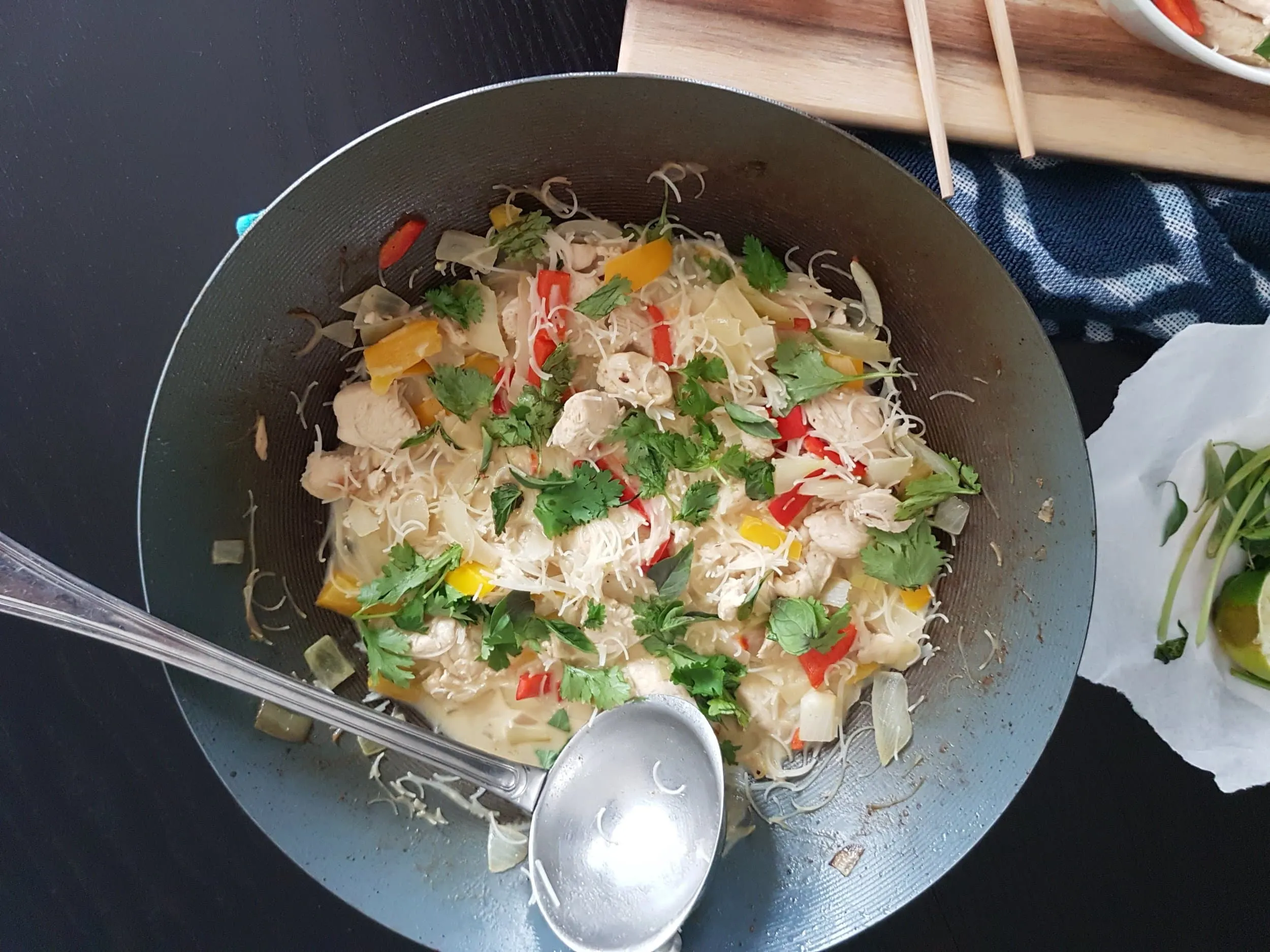 A wok full of Thai Green Coconut Curry Chicken with Rice Noodles.