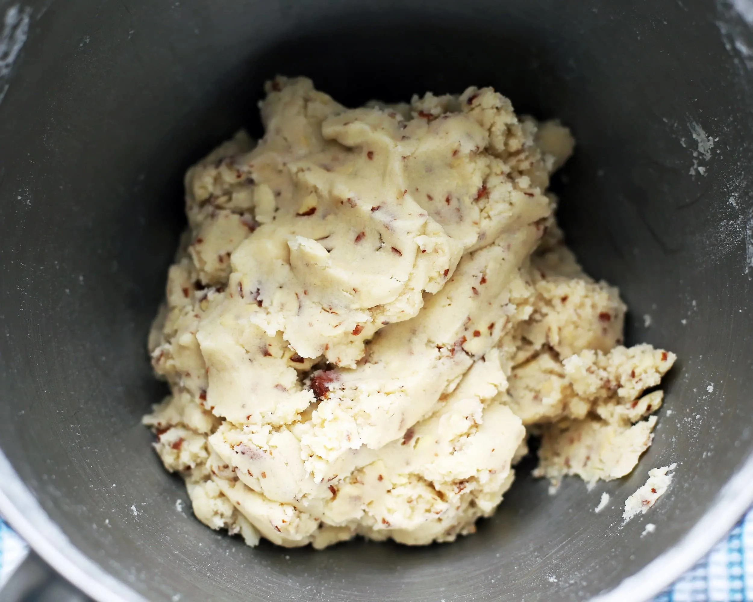 Six ingredient almond cookie dough in a metal bowl.