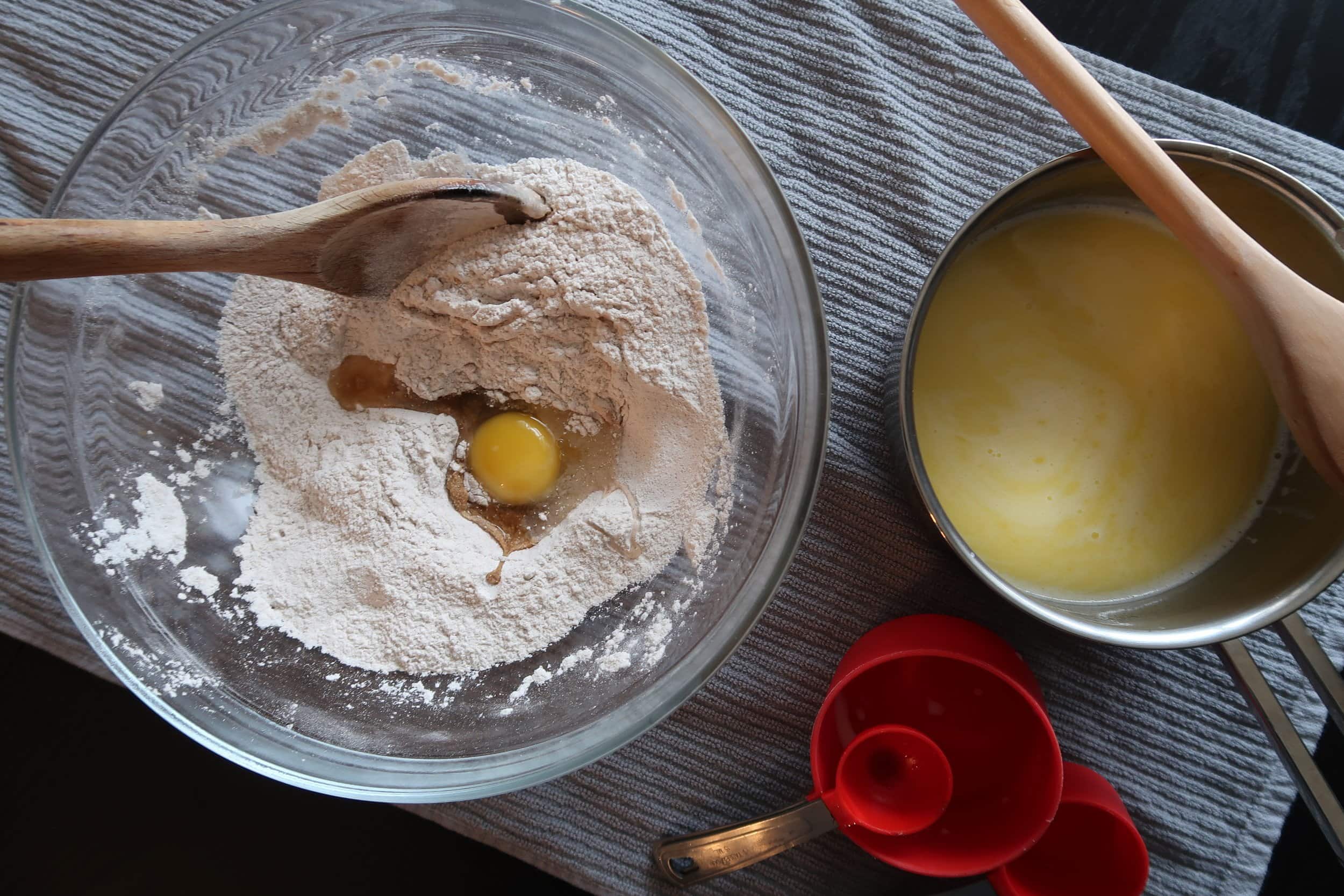 Eggs being added to the dry ingredients for cinnamon roll dough.