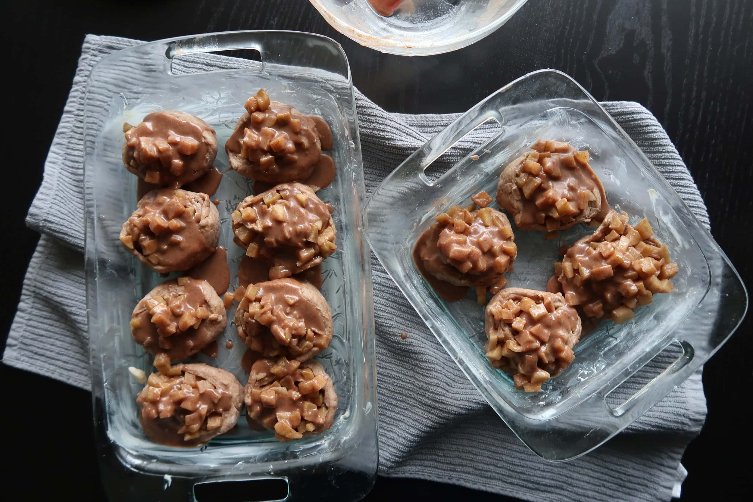 Sauce poured over Apple Cinnamon Rolls in two baking dishes.