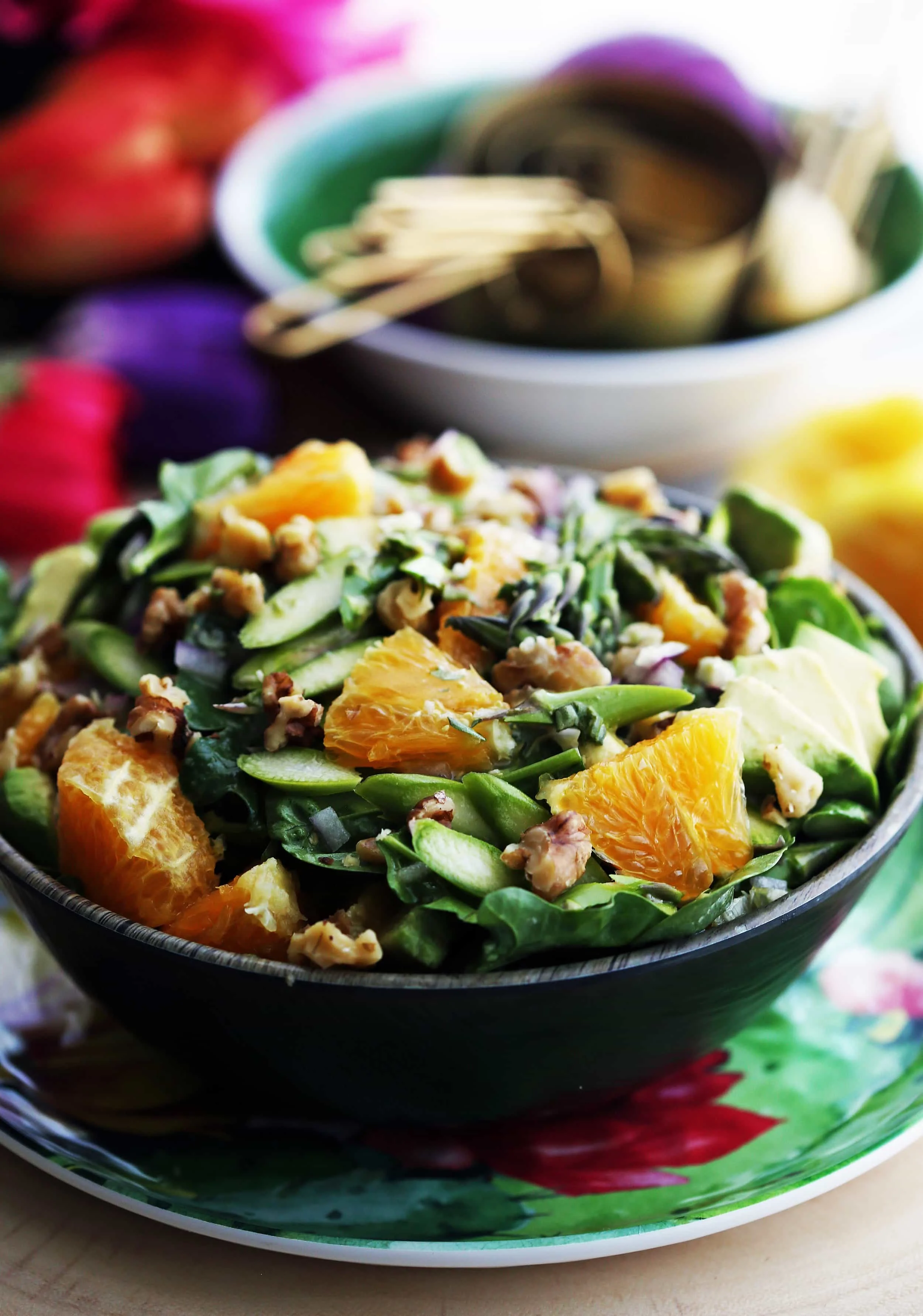 A closeup view of a bowl of Asparagus Orange Spinach Salad with Basil Lemon Vinaigrette