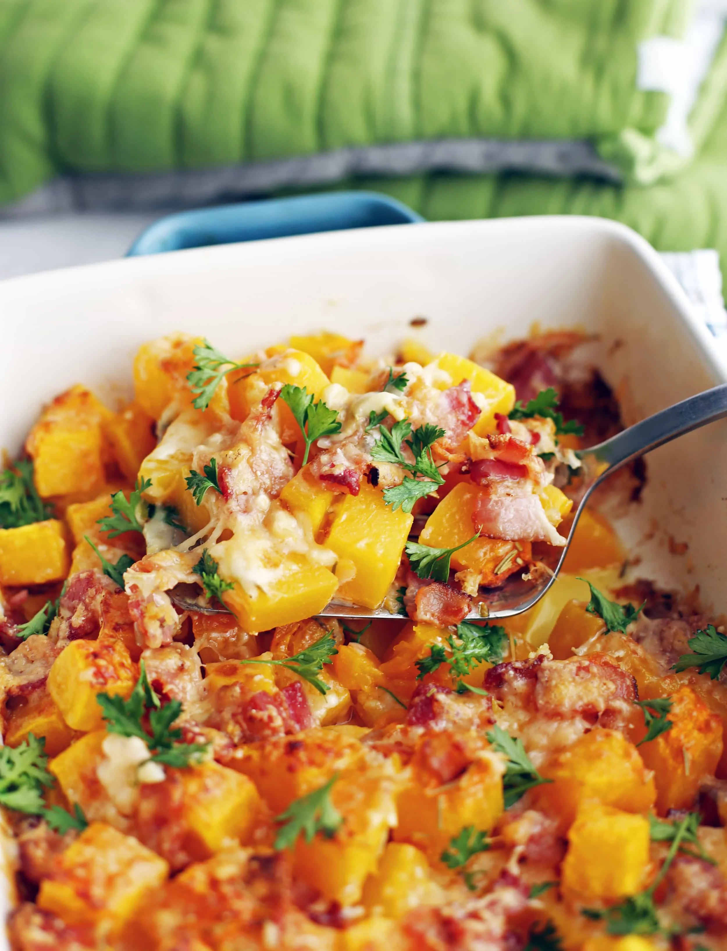 A scoop of Baked Bacon Cheese Butternut Squash on a metal spatula.