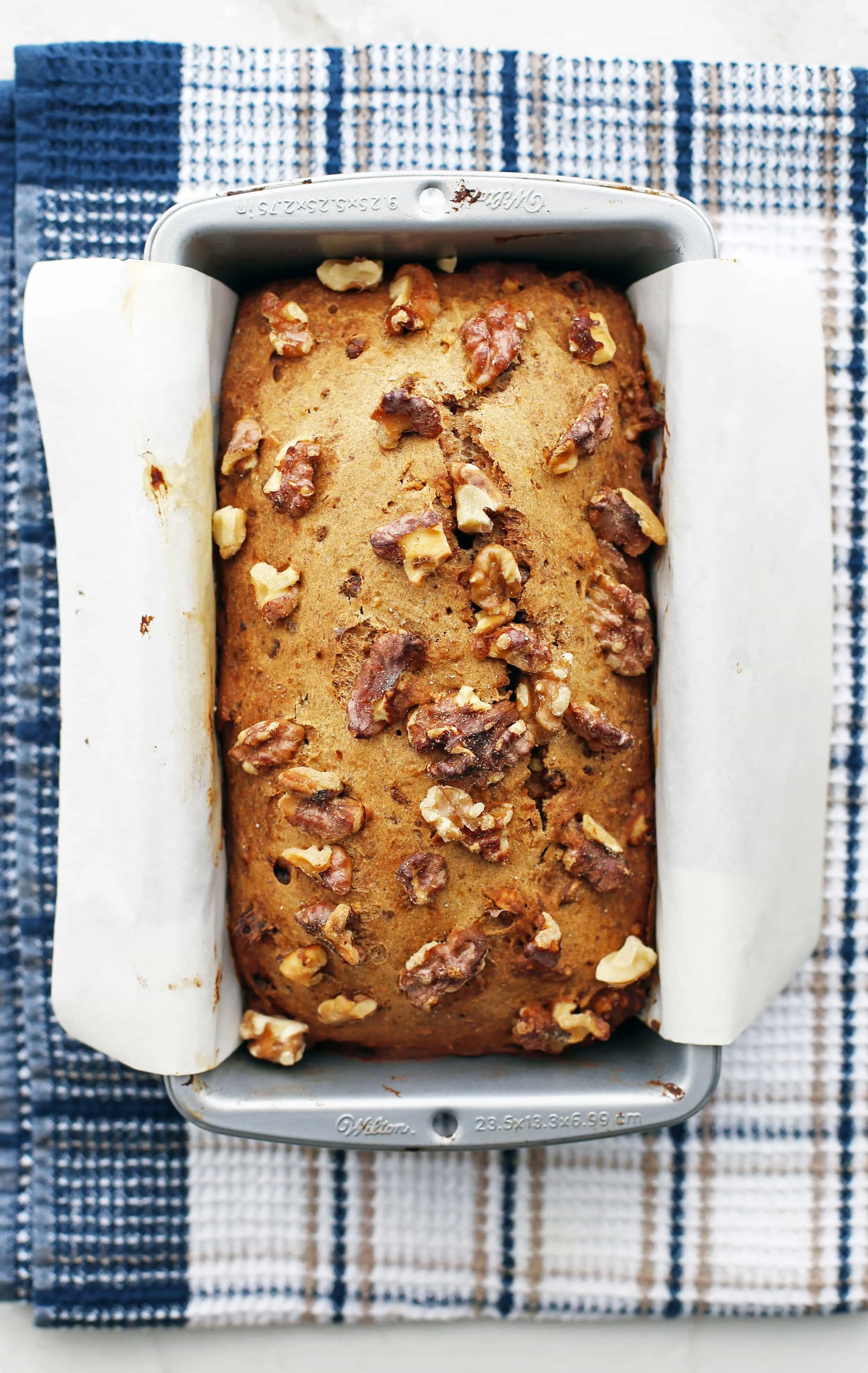 Freshly baked Date Banana Nut Bread in a parchment paper-lined loaf pan.