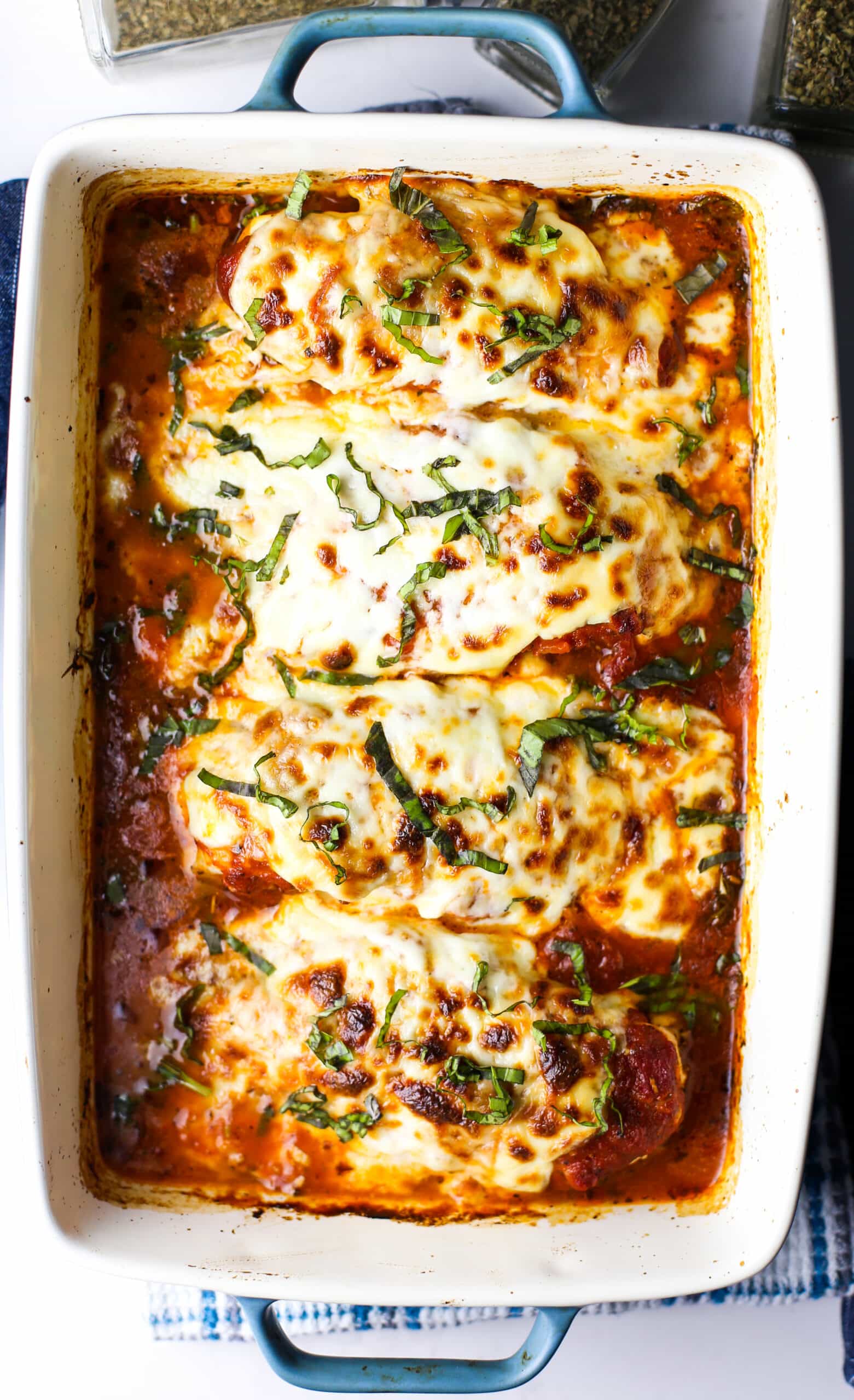 Baked mozzarella chicken with marinara sauce in a casserole dish.