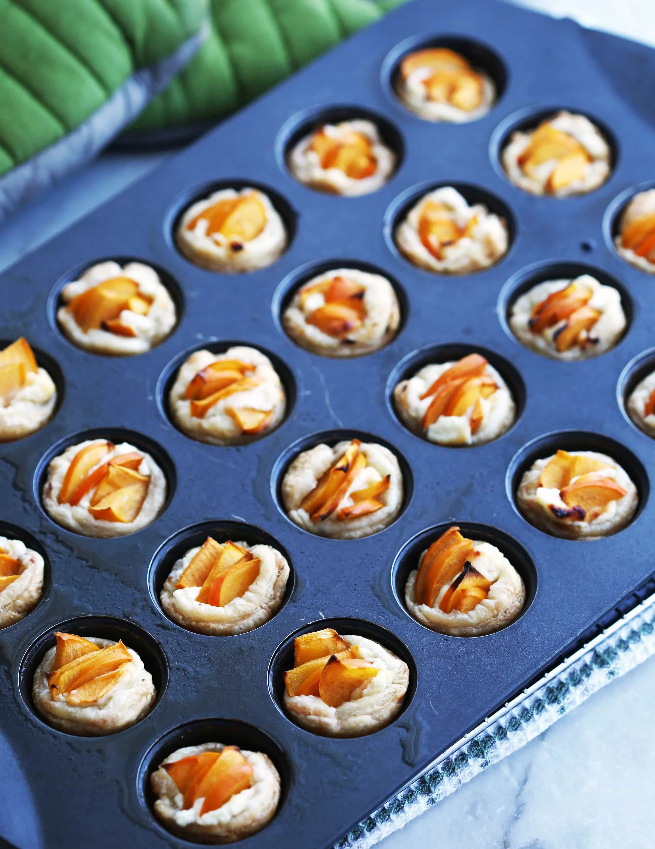 Baked Persimmon Goat Cheese Tartlets in a mini muffin pan.