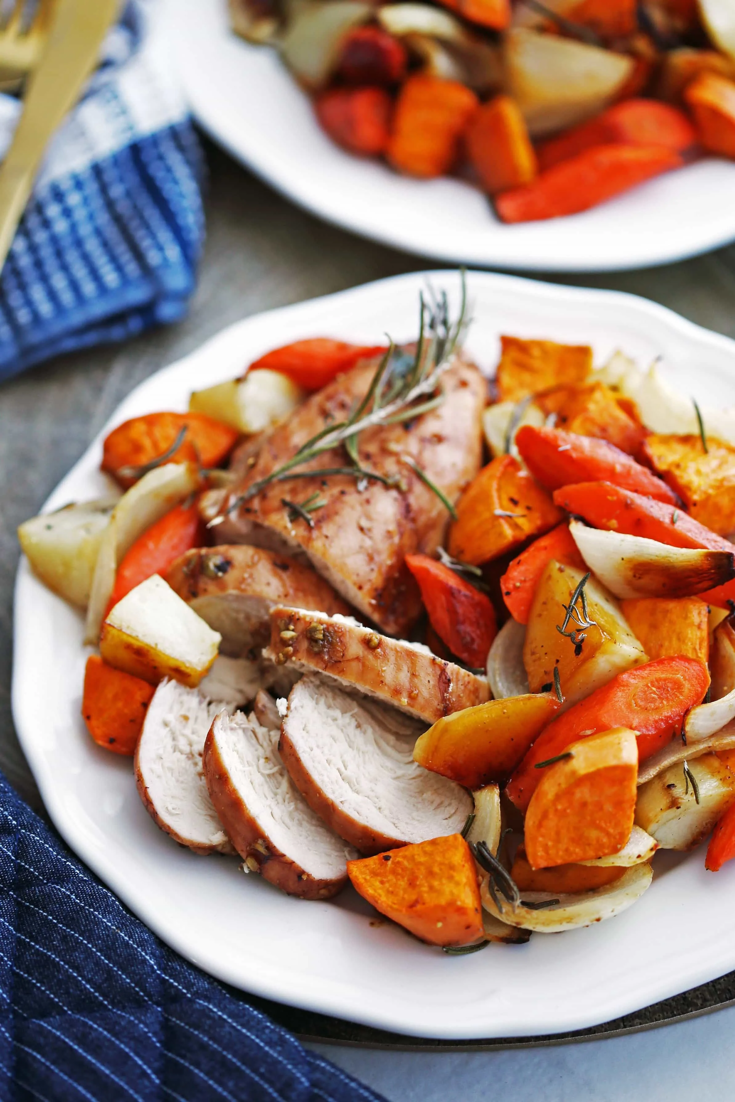 Sheet pan balsamic chicken with potatoes and carrots on a white plate.