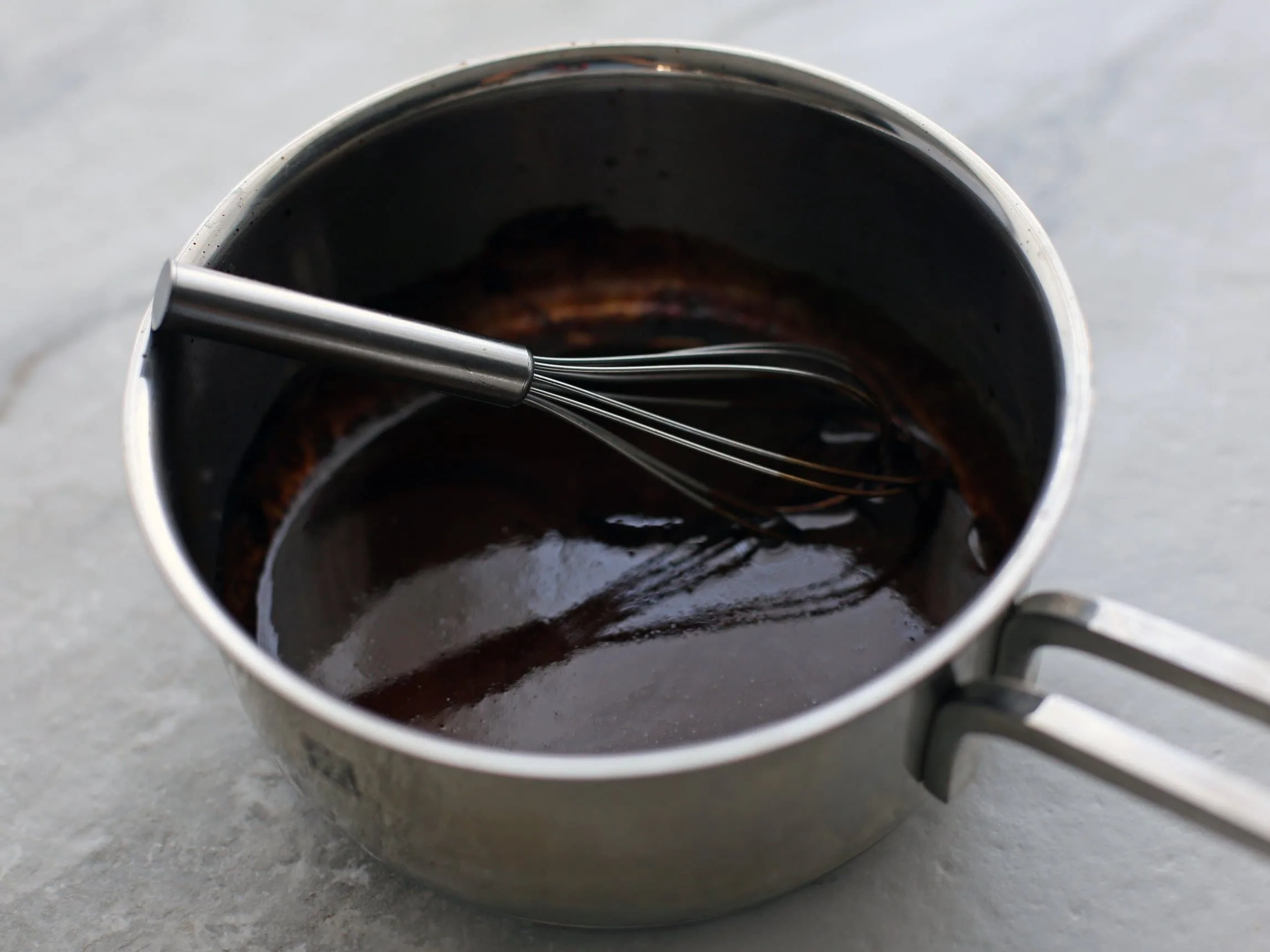 Reduced balsamic vinegar in a small metal pot.