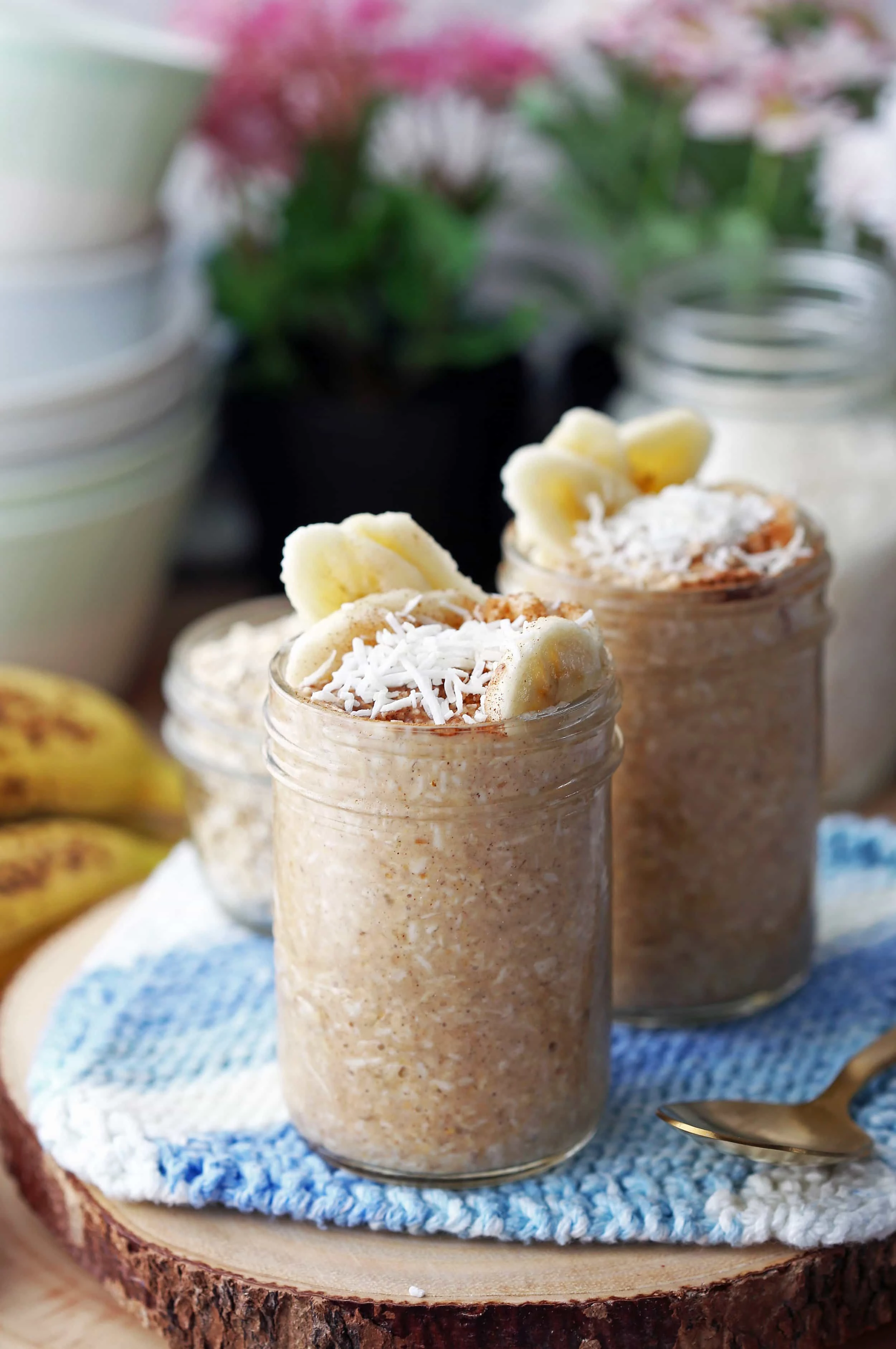 Two mason jars filled with Banana Coconut Cream Pie Overnight Oats.