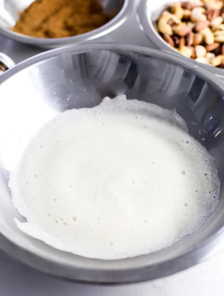Beaten egg whites in a stainless steel bowl.