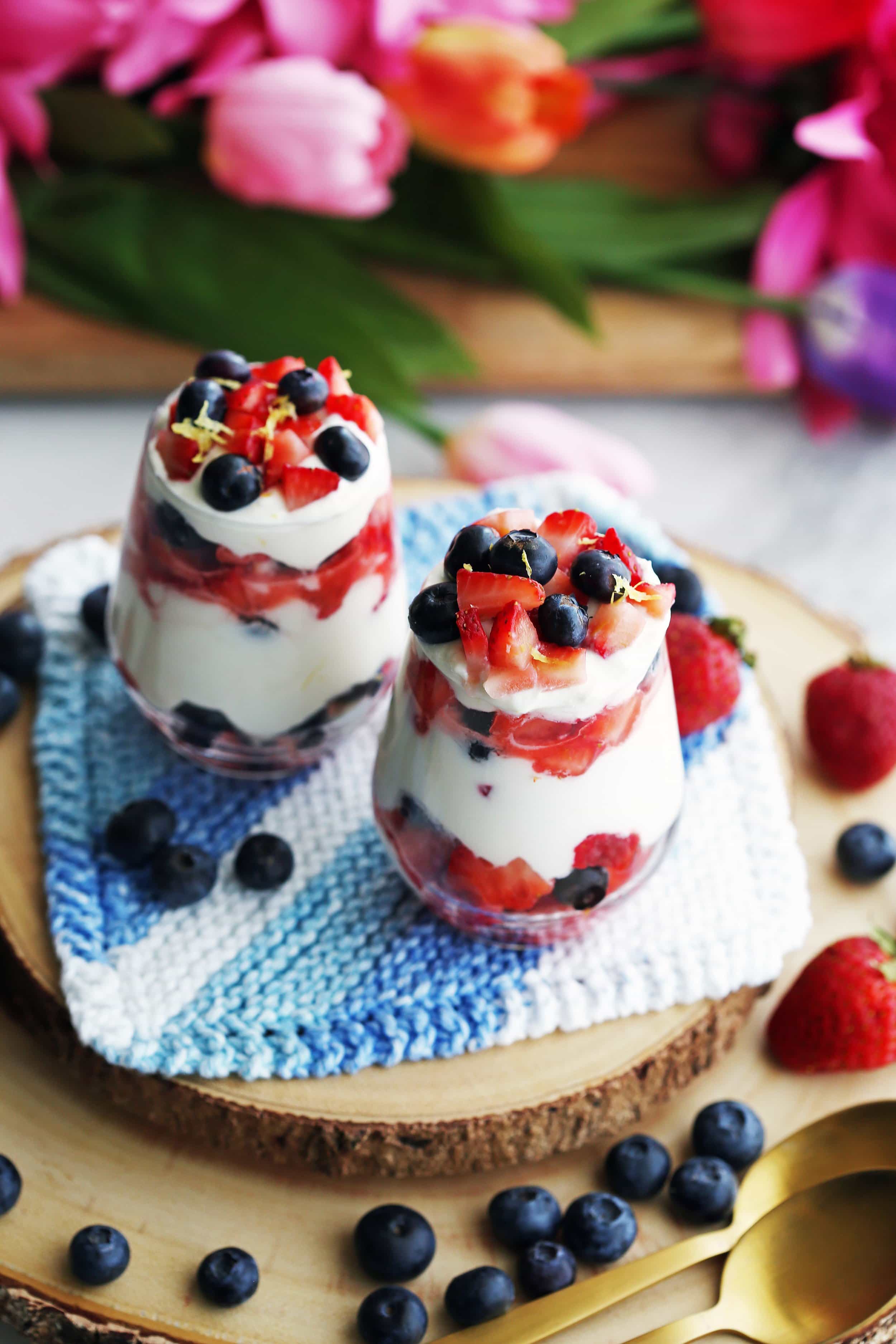 Layered fresh strawberries, blueberries, and honey lemon mascarpone cream in two glasses.