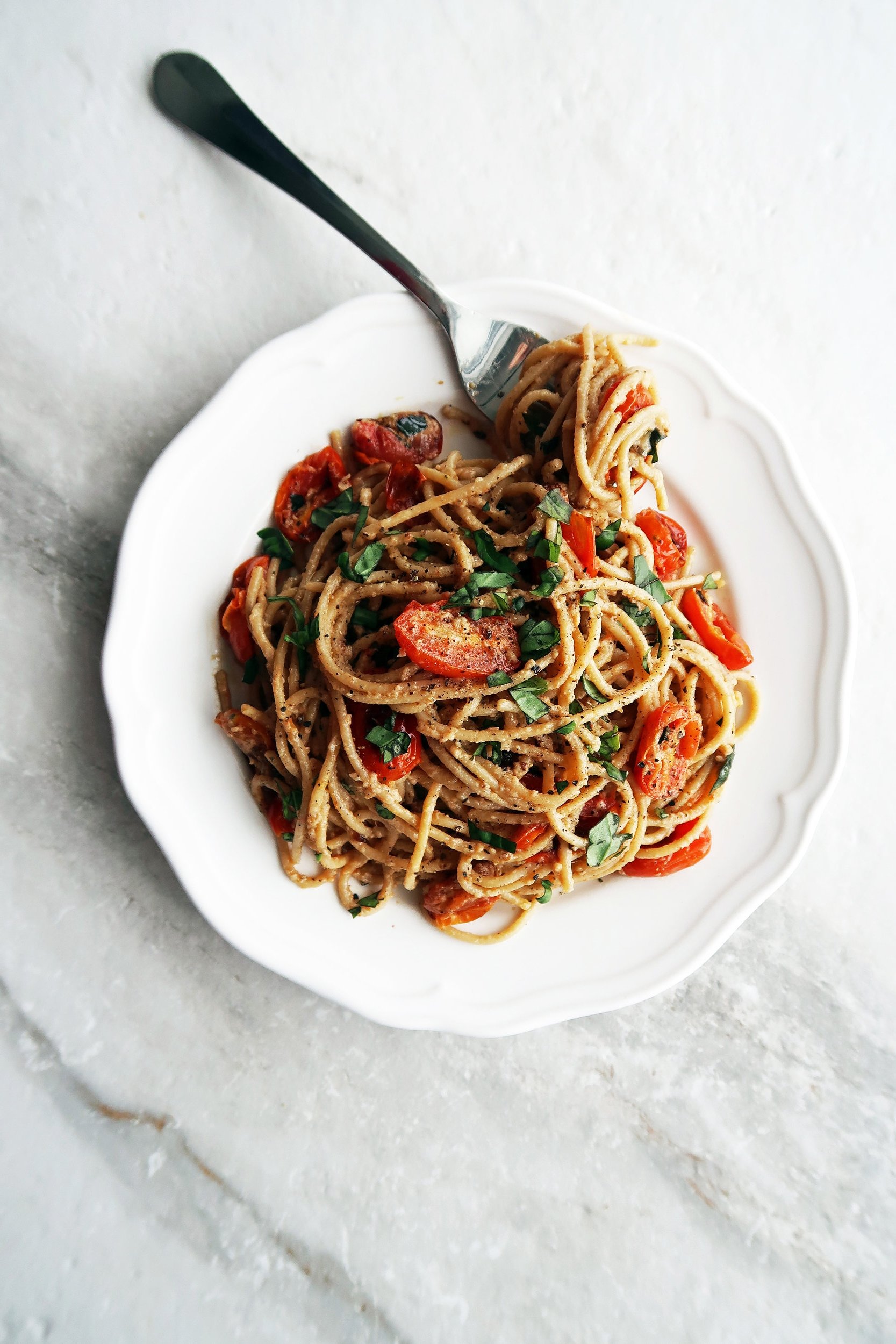 Black Pepper and Parmesan Spaghetti with Garlic Roasted Tomatoes (cheese and pepper pasta) on a white plate.