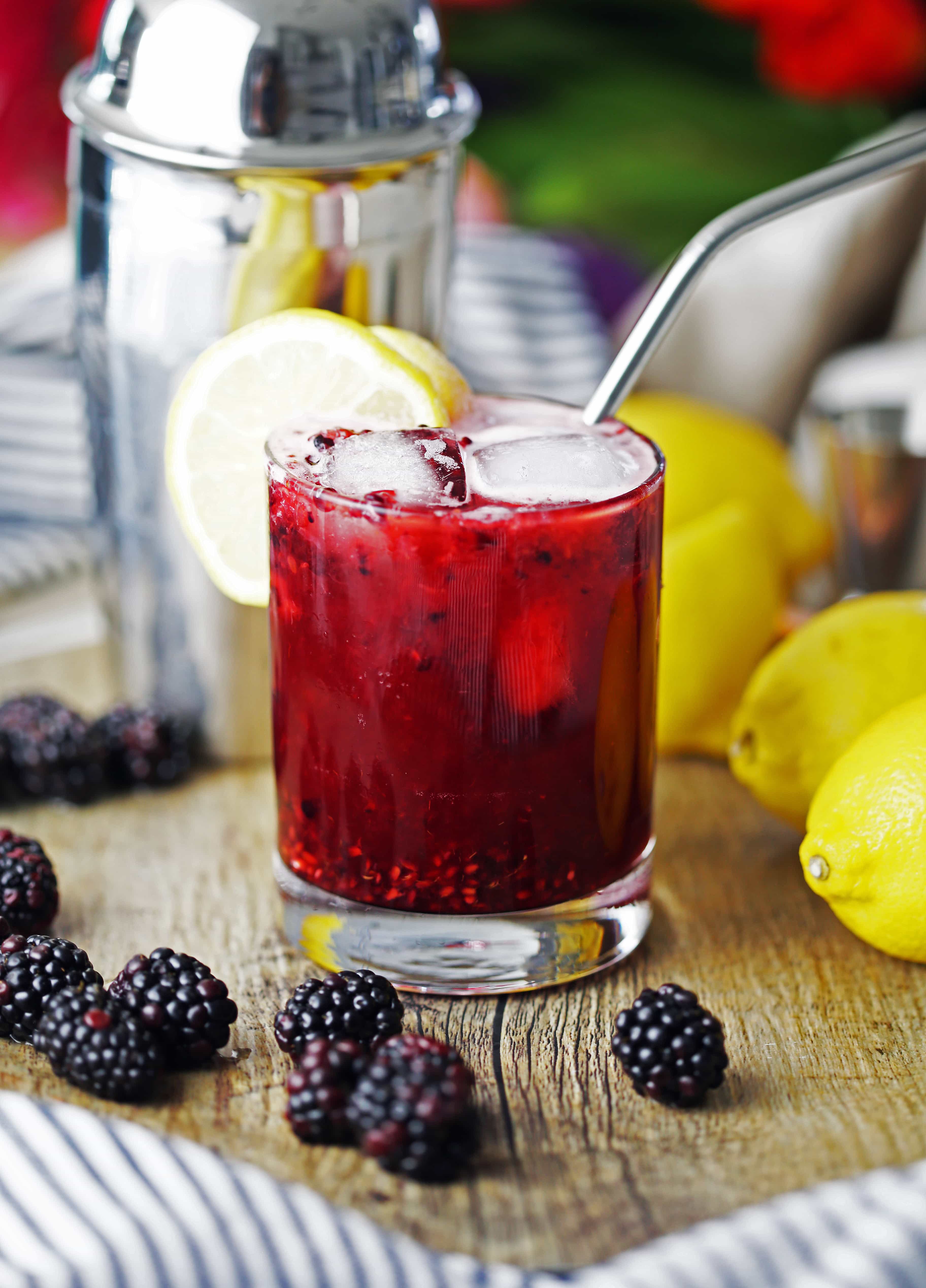 Blackberry lemon smash made with gin in a double old-fashioned glass with a lemon slice.