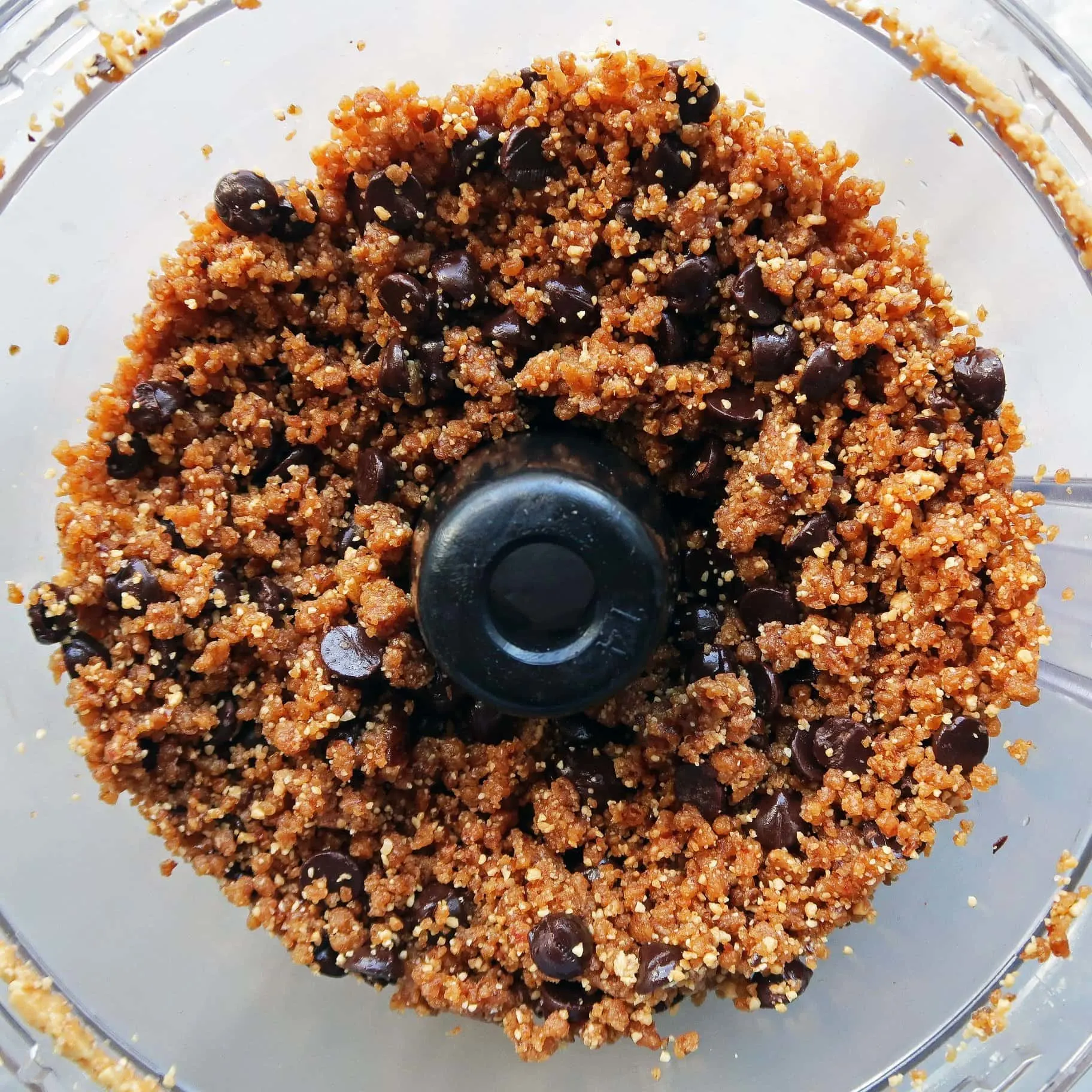 Finely pulsed peanuts and dates with whole chocolate chips in a food processor.