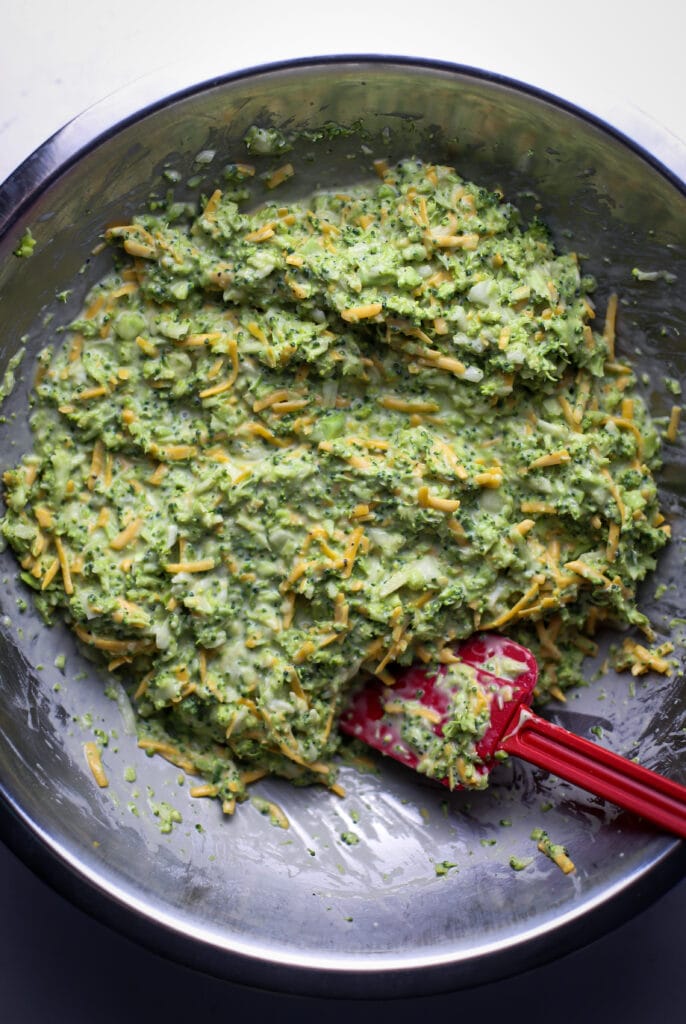 Broccoli cheddar flour mixture in a stainless steel bowl.