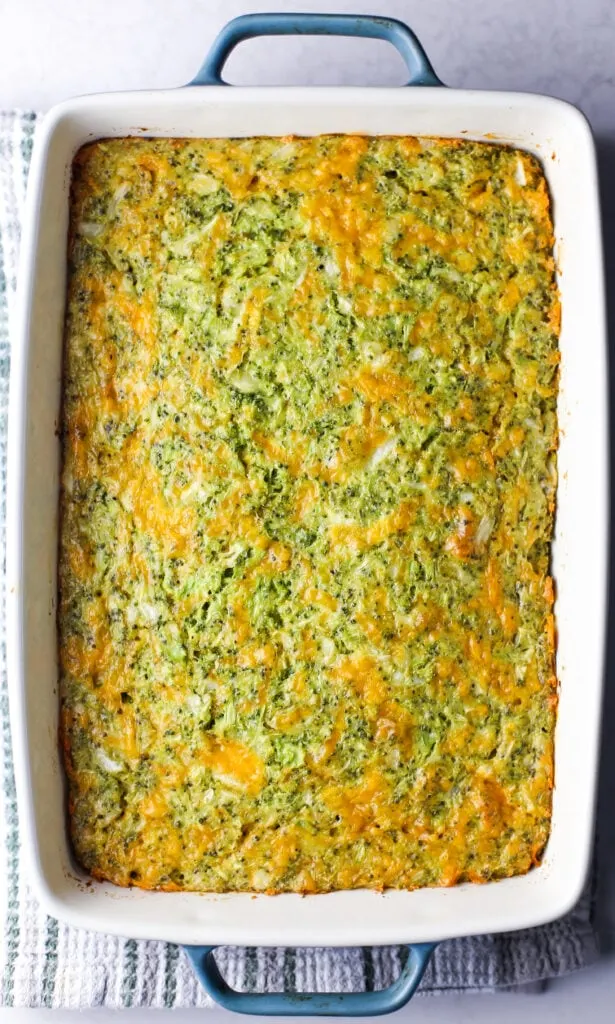 Freshly baked broccoli cheddar squares (pre-sliced) in a rectangular baking dish.