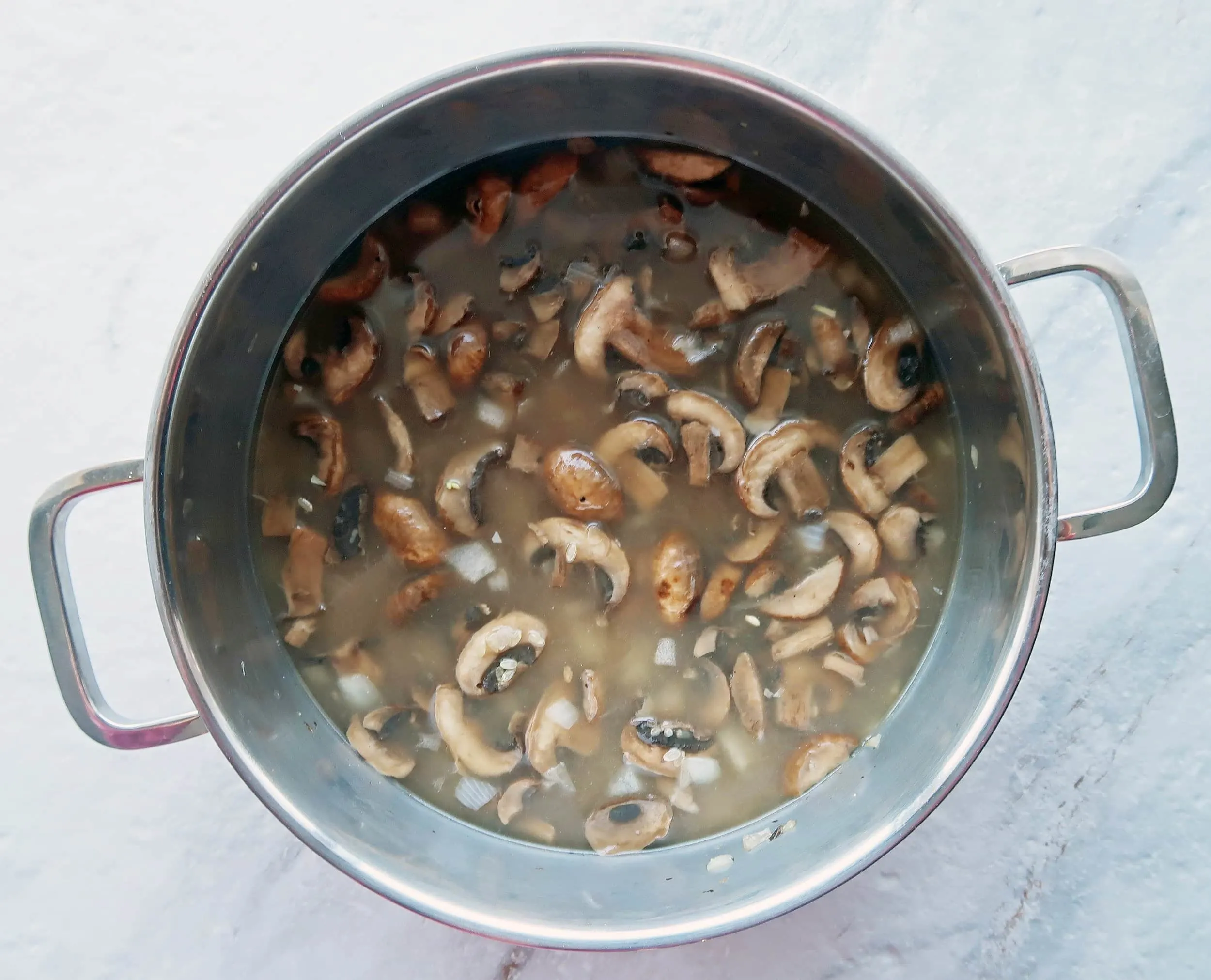 A pot of mushrooms in broth.