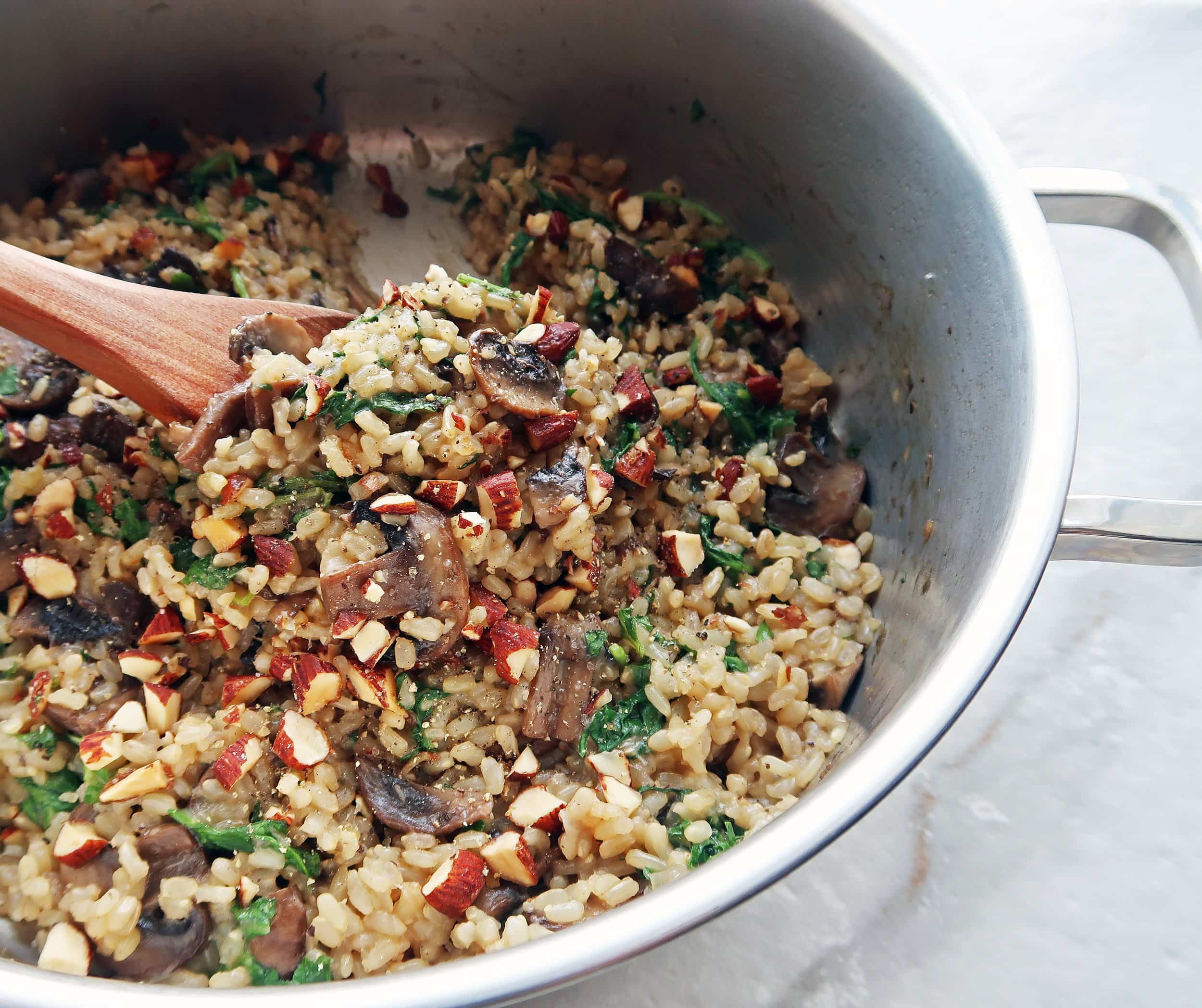 A wooden spoon holding up rice pilaf.