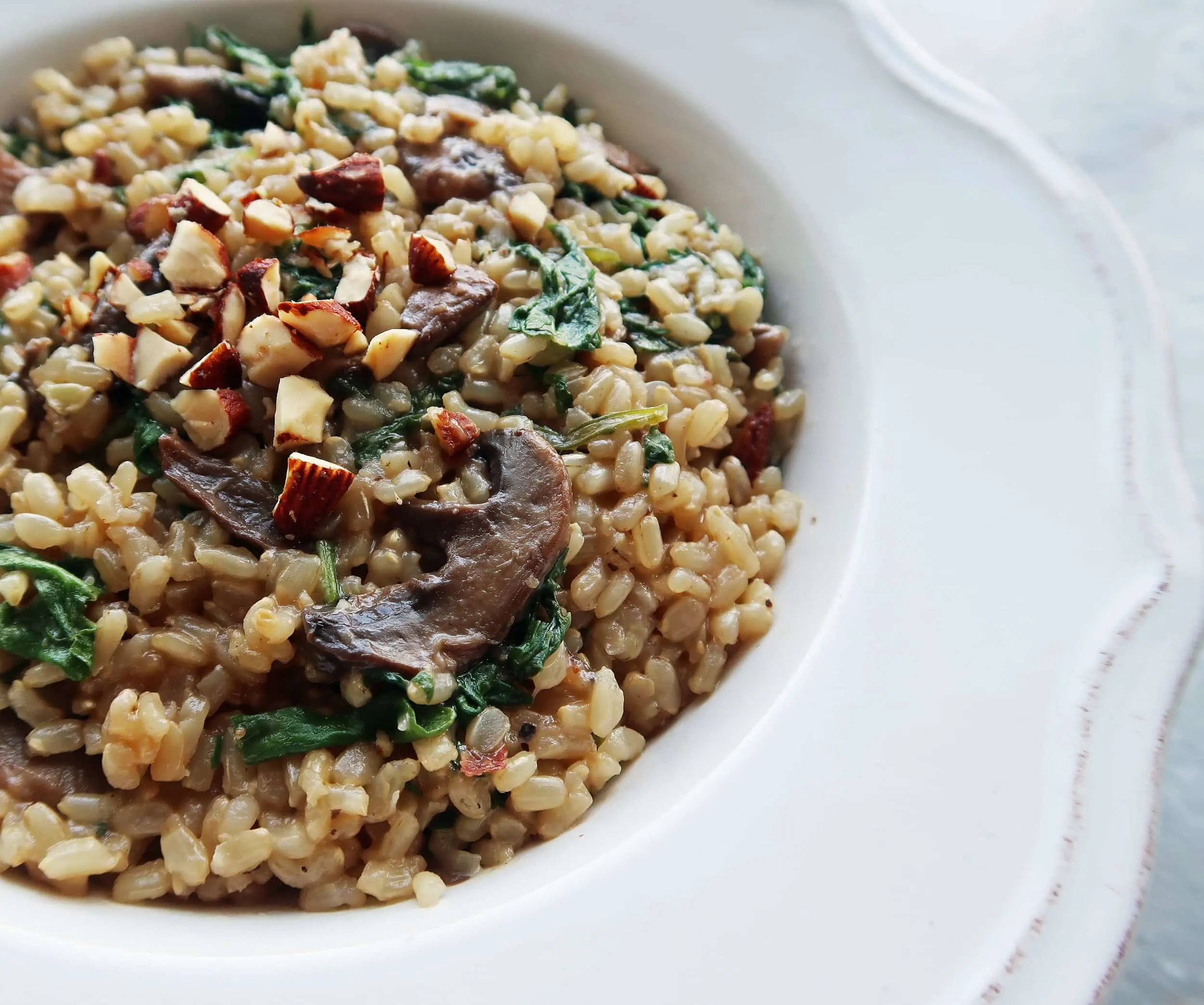 A close up of a bowl of Brown Rice Pilaf with Mushrooms, Kale, and Almonds