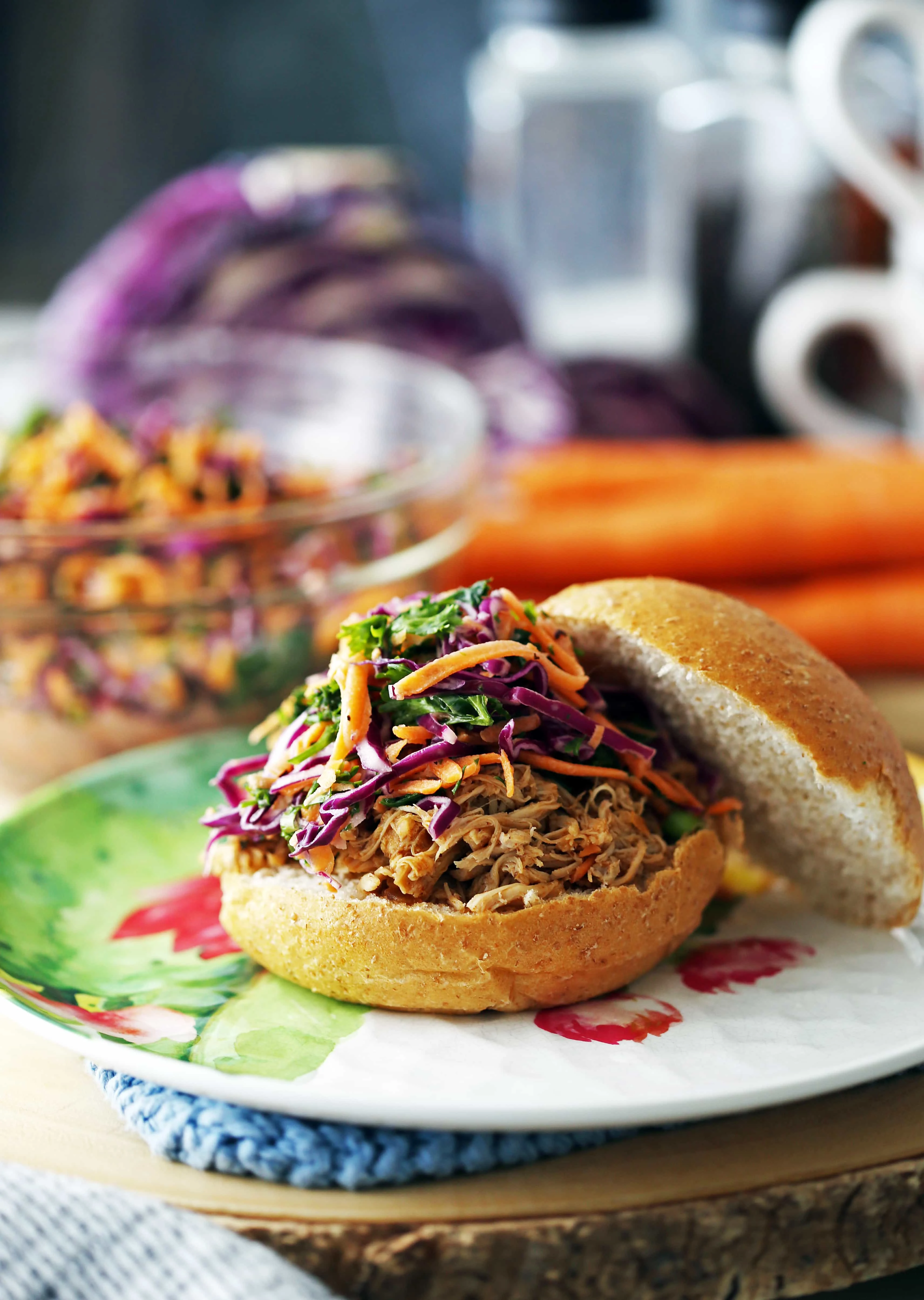 A side view of shredded chicken burger with healthy carrot cabbage slaw topping.