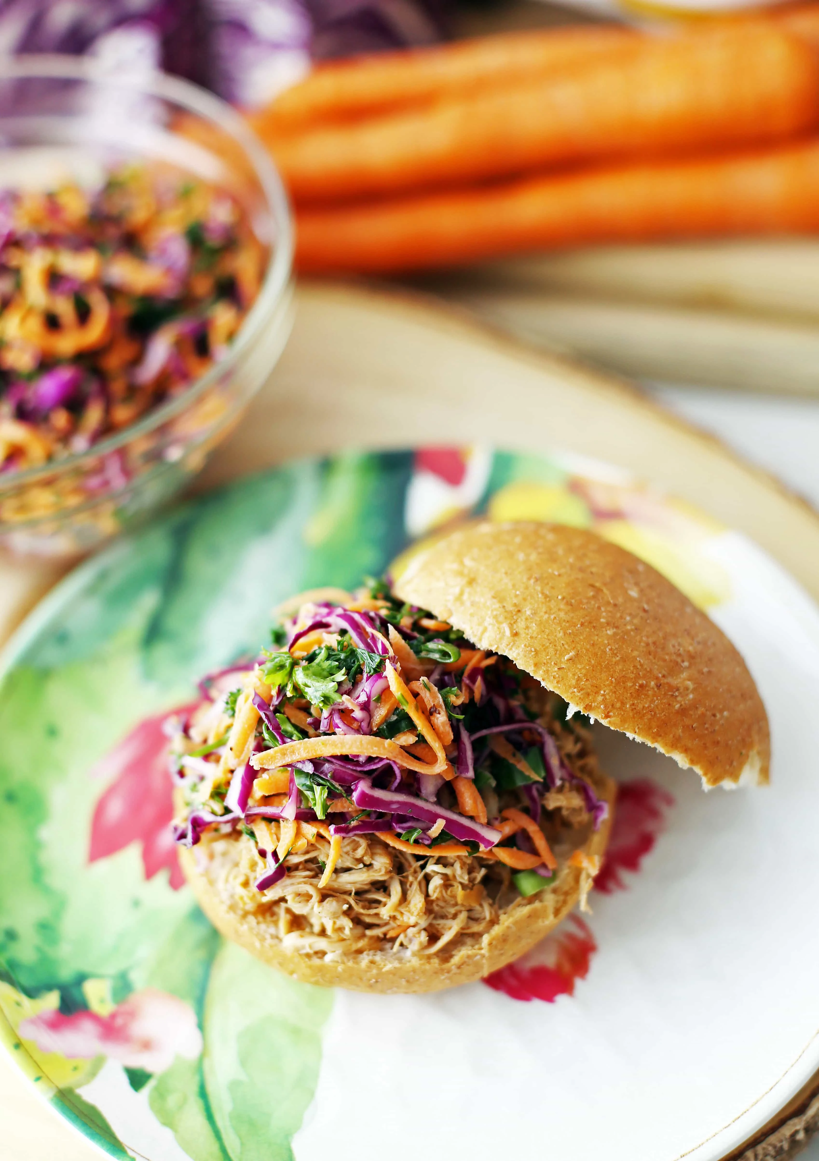 A pulled chicken burger with healthy carrot cabbage slaw topping.