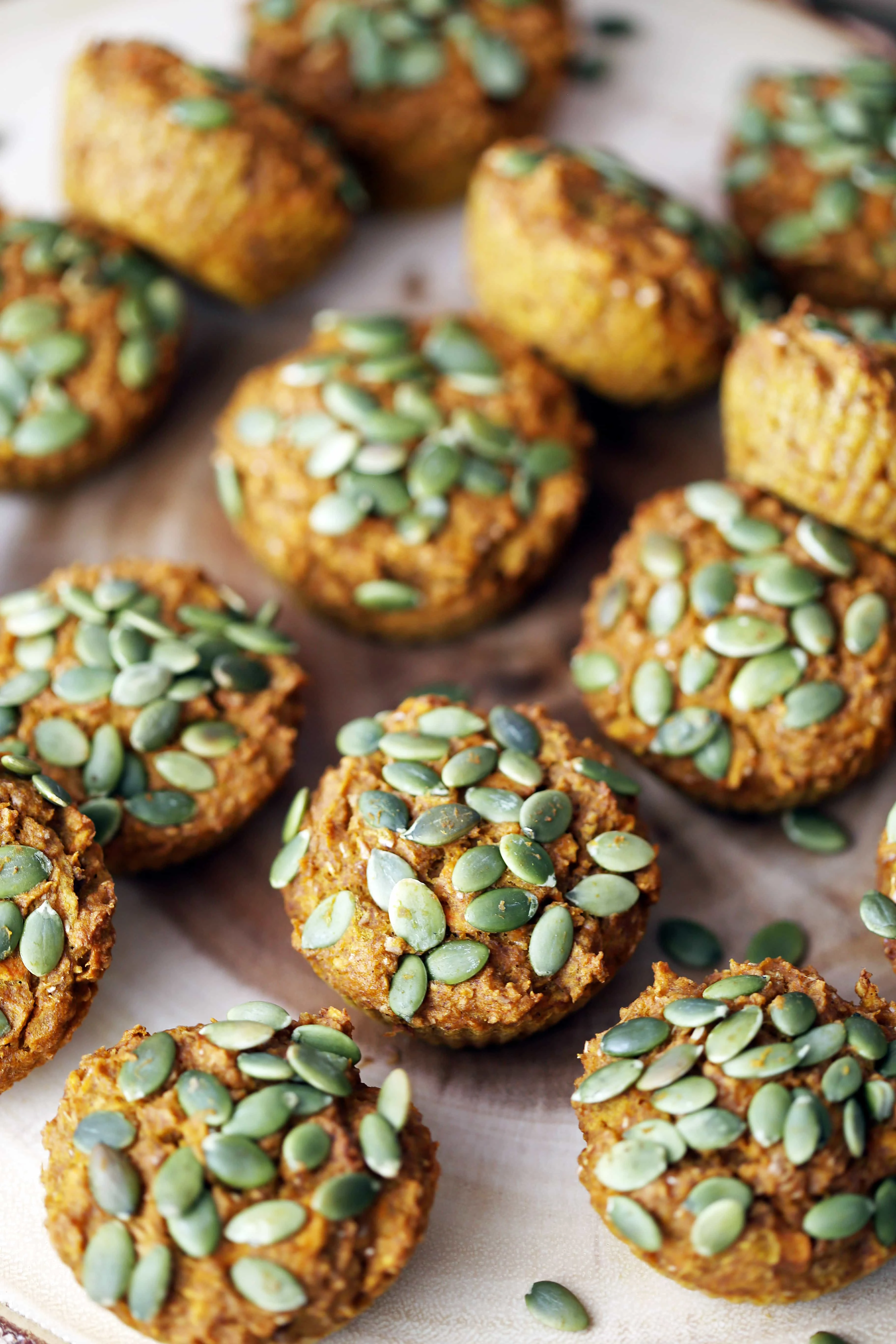 Carrot pumpkin muffins on a round wooden platter.