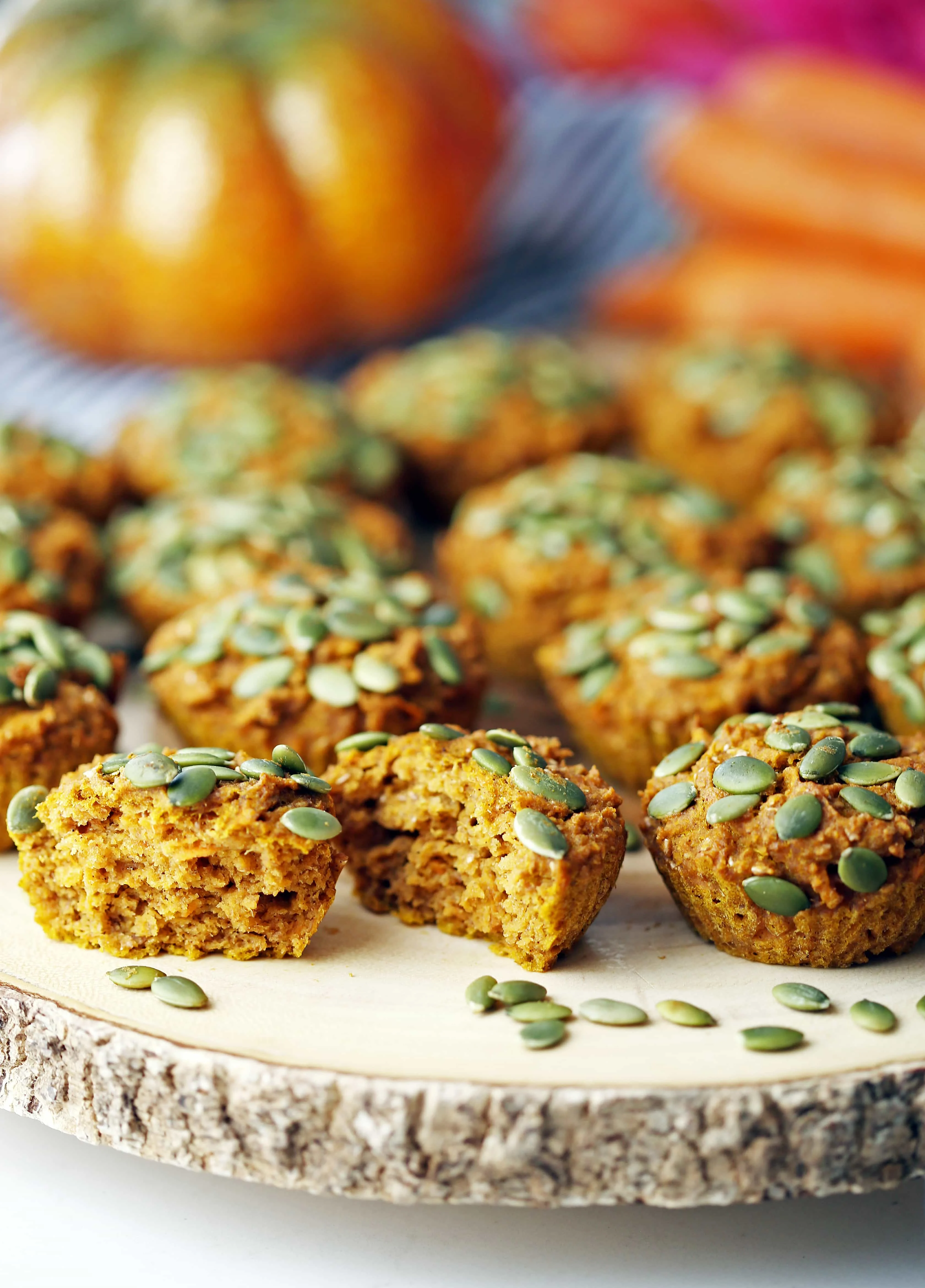 A dozen carrot pumpkin muffins placed on a wooden board.