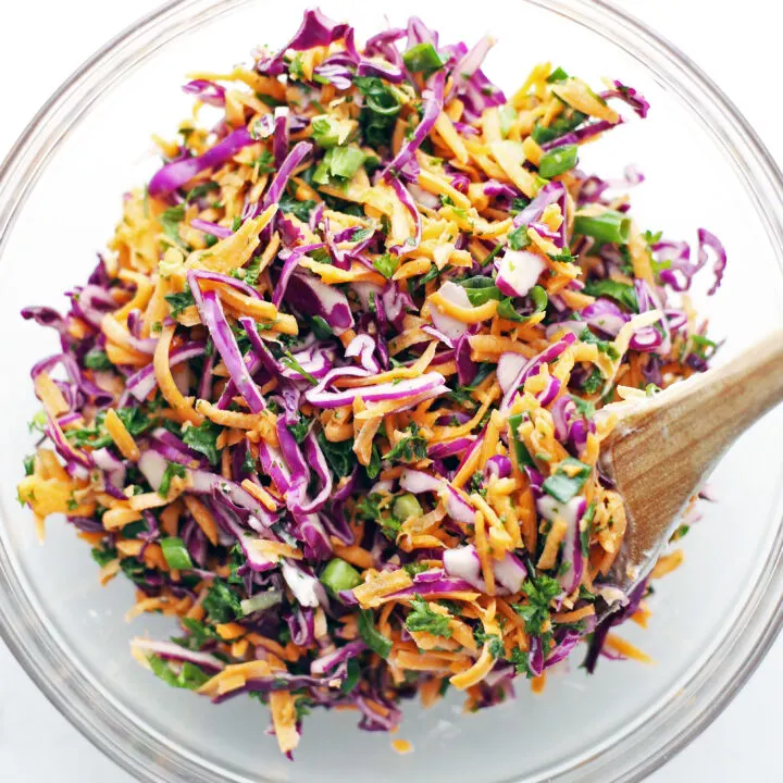 A glass bowl containing colourful and healthy carrot cabbage coleslaw.