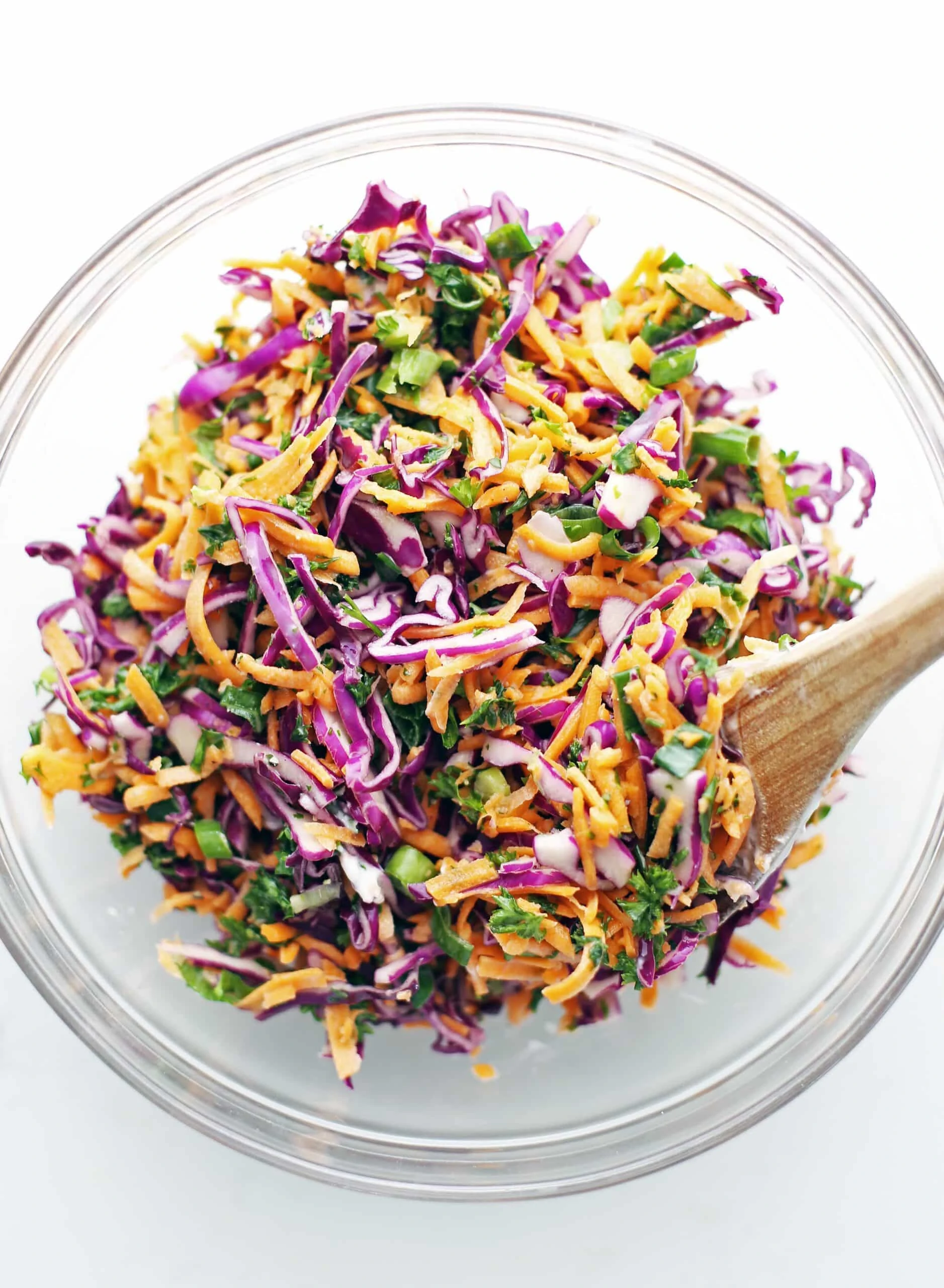 A glass bowl containing colourful and healthy carrot cabbage coleslaw.