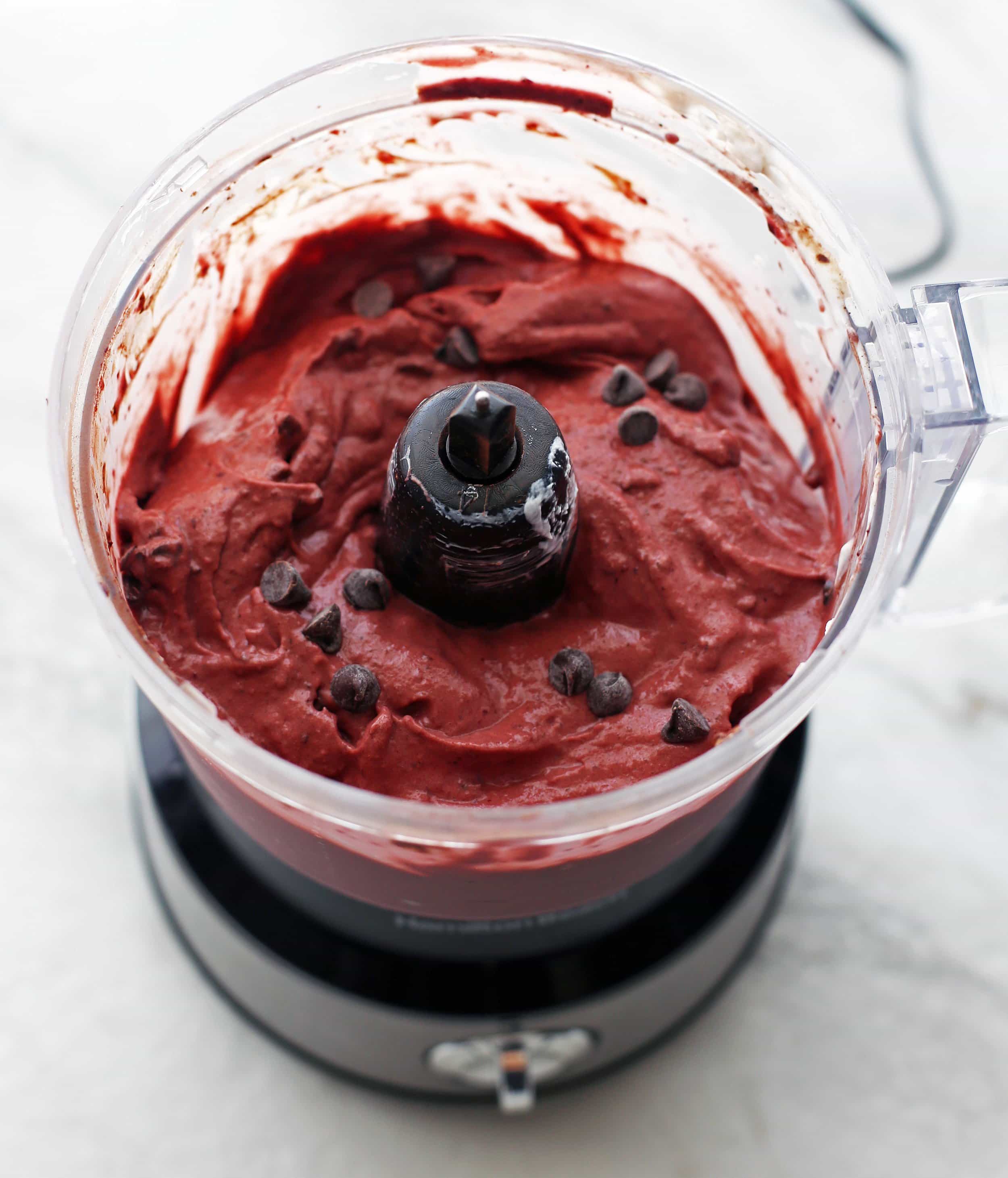 Creamy cherry chocolate frozen yogurt with chocolate chips in a food processor.