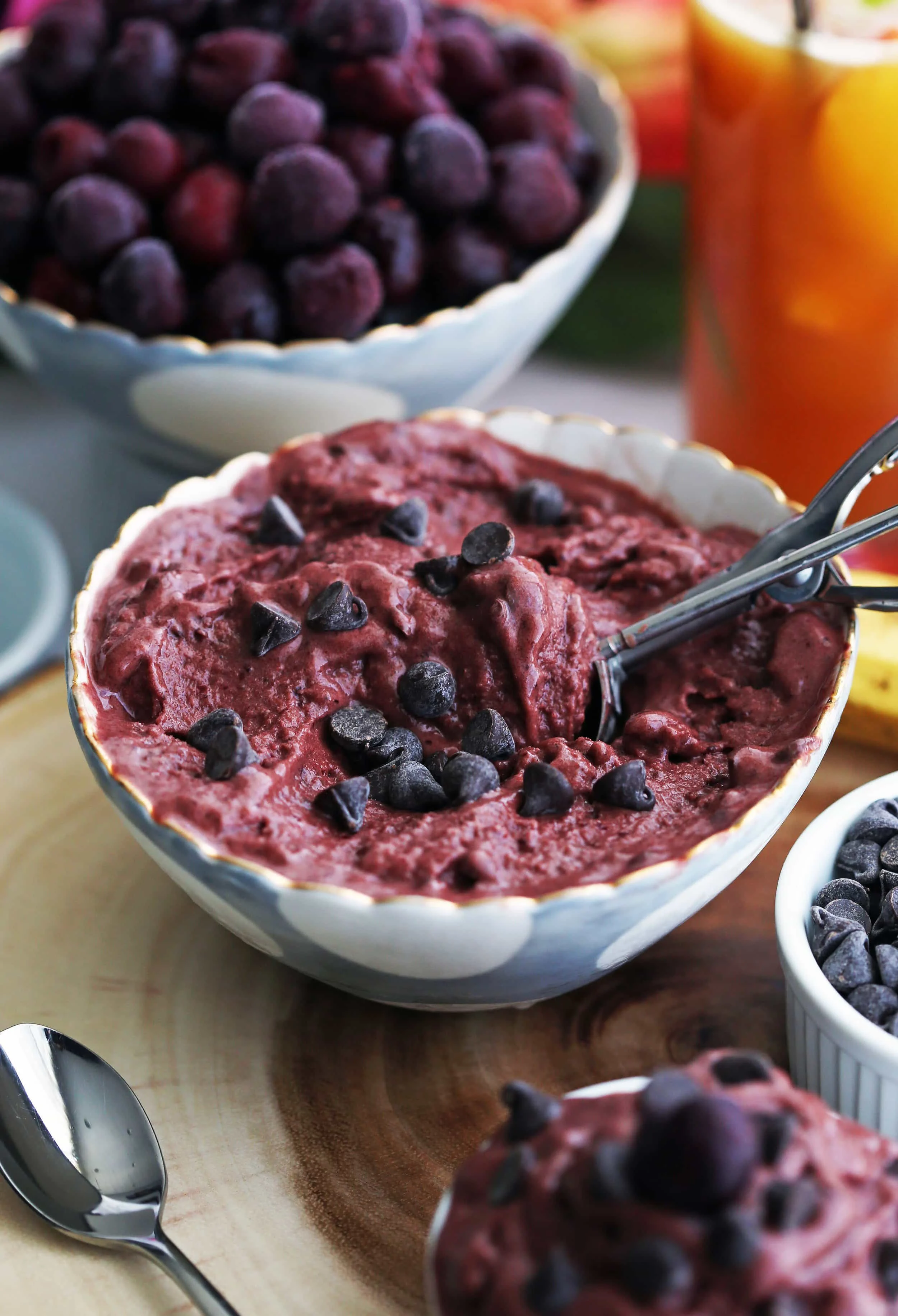 A blue and white bowl full of cherry chocolate frozen yogurt with chocolate chips on top.