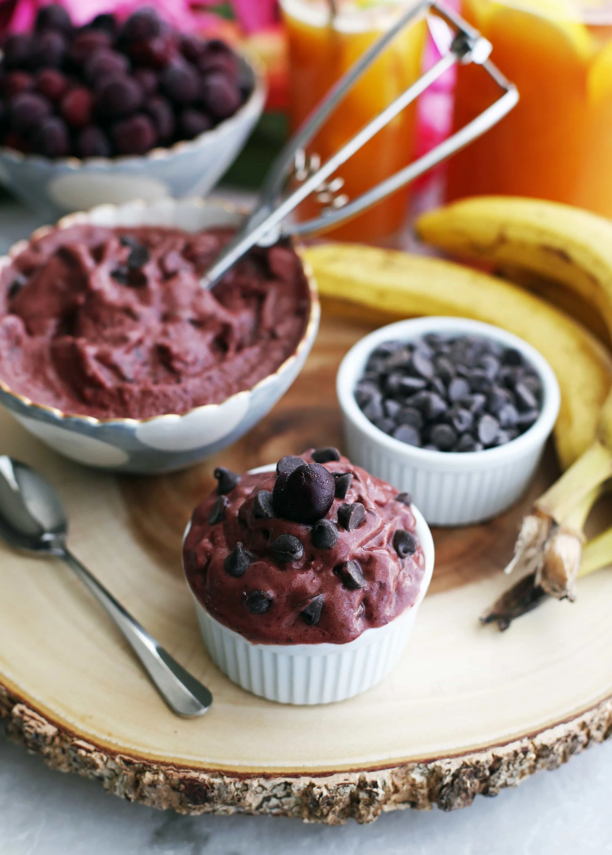 A small white bowl full of cherry chocolate frozen yogurt with chocolate chips and cherry on top.