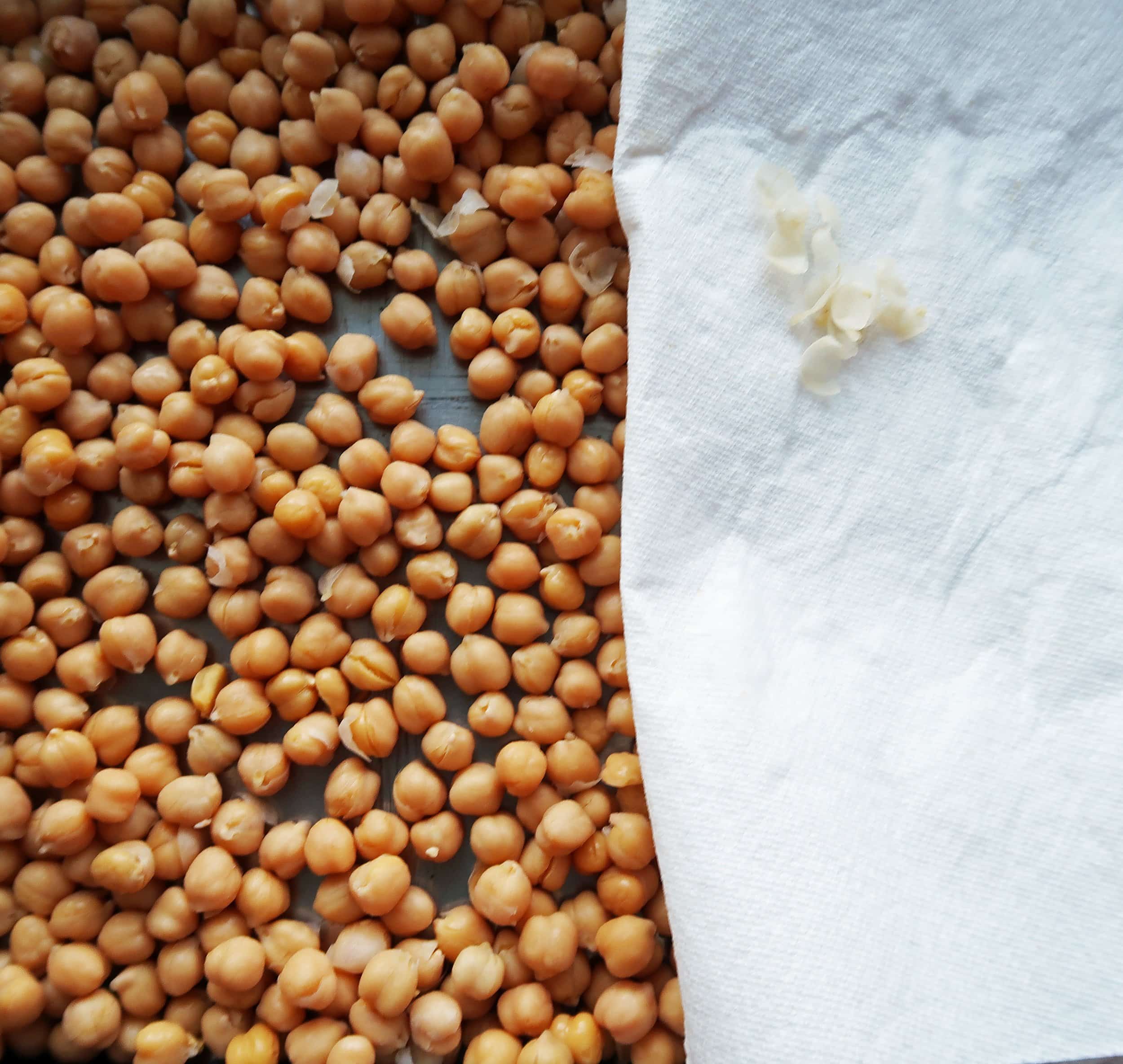 Chickpeas on one half of a baking sheet.