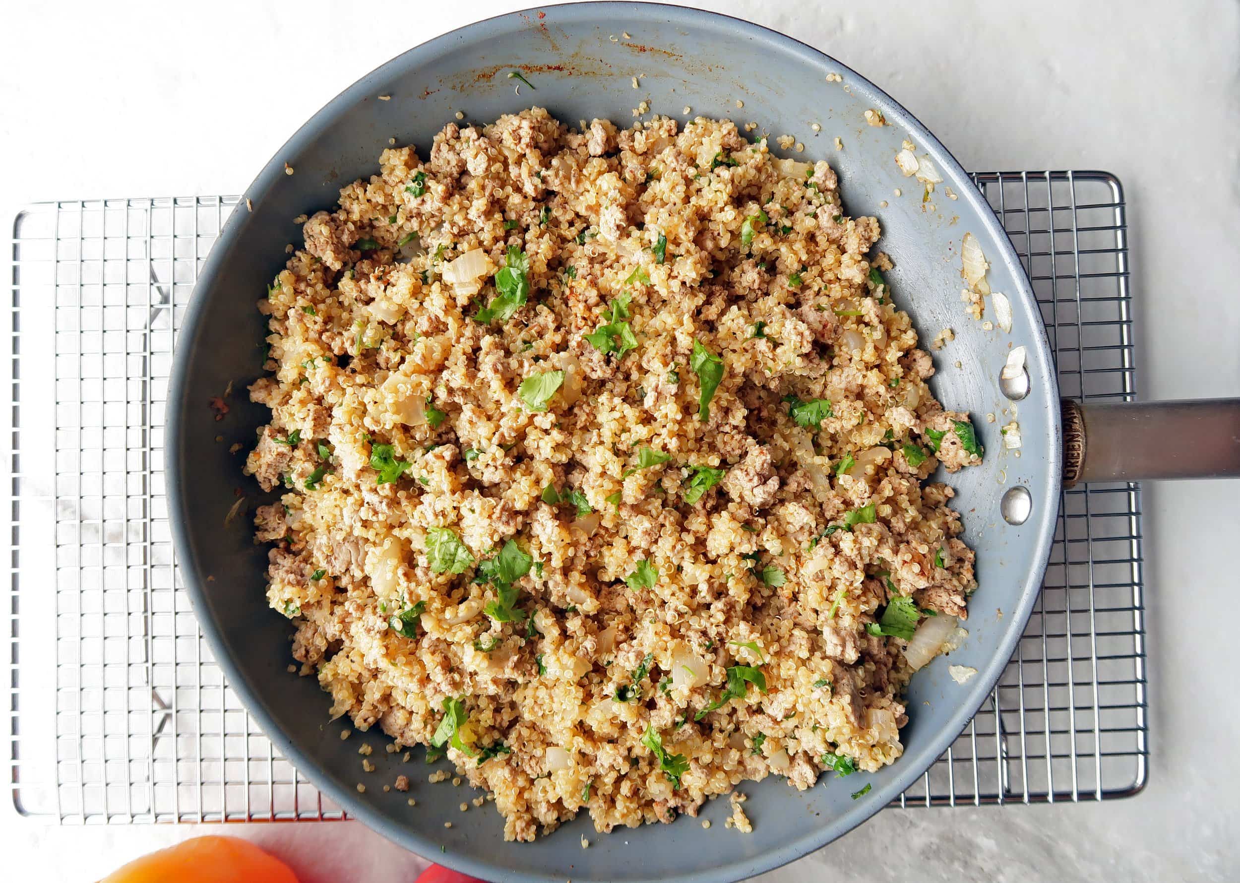 Freshly cooked ground turkey in a frying pan with quinoa and cilantro.