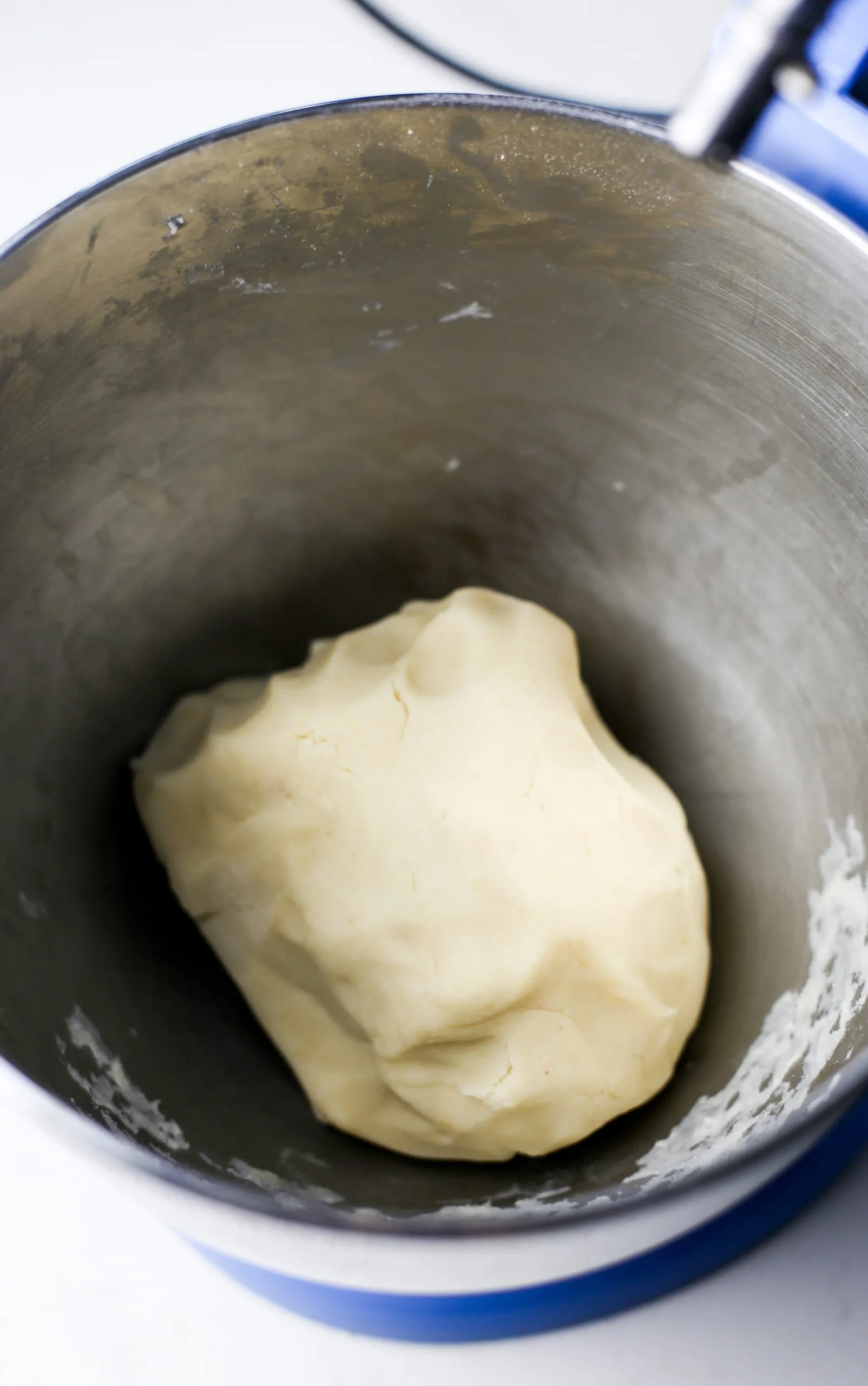 Smooth and round condensed milk cookie dough ball in a mixing bowl.