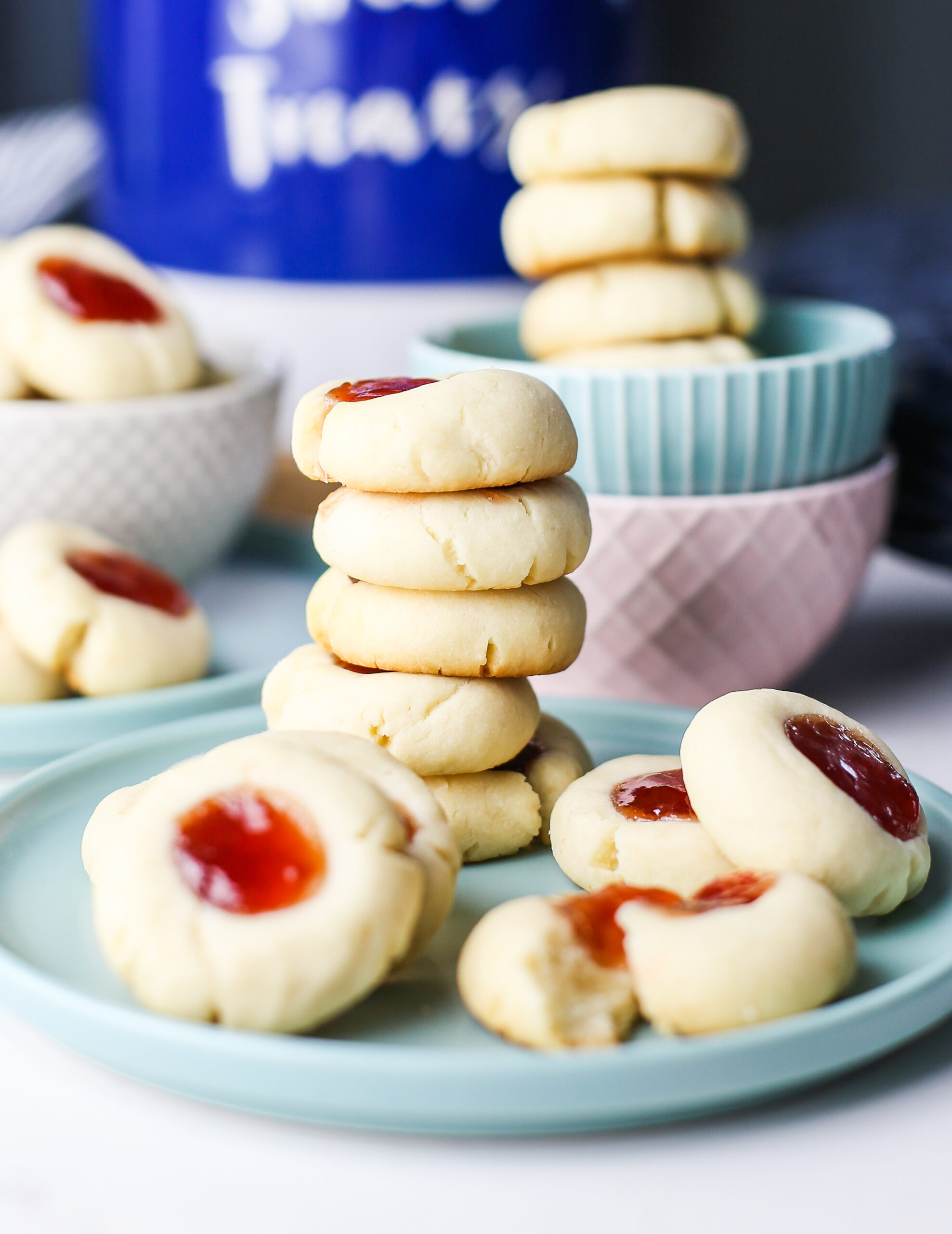 5-Ingredient Condensed Milk Thumbprint Cookies on colourful bowls and plates.