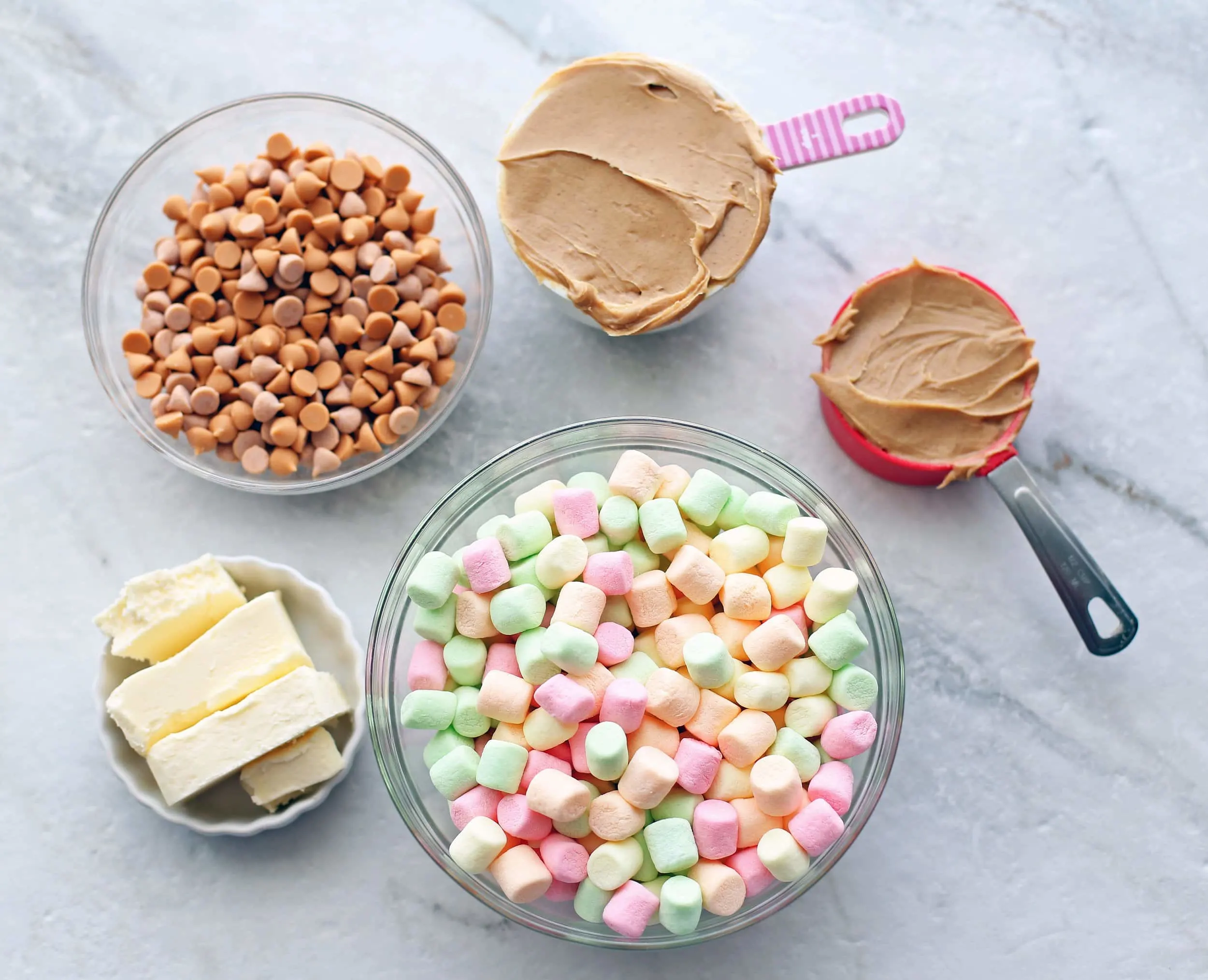 Overhead shot of colourful marshmallows, butter, peanut butter, and butterscotch chips.