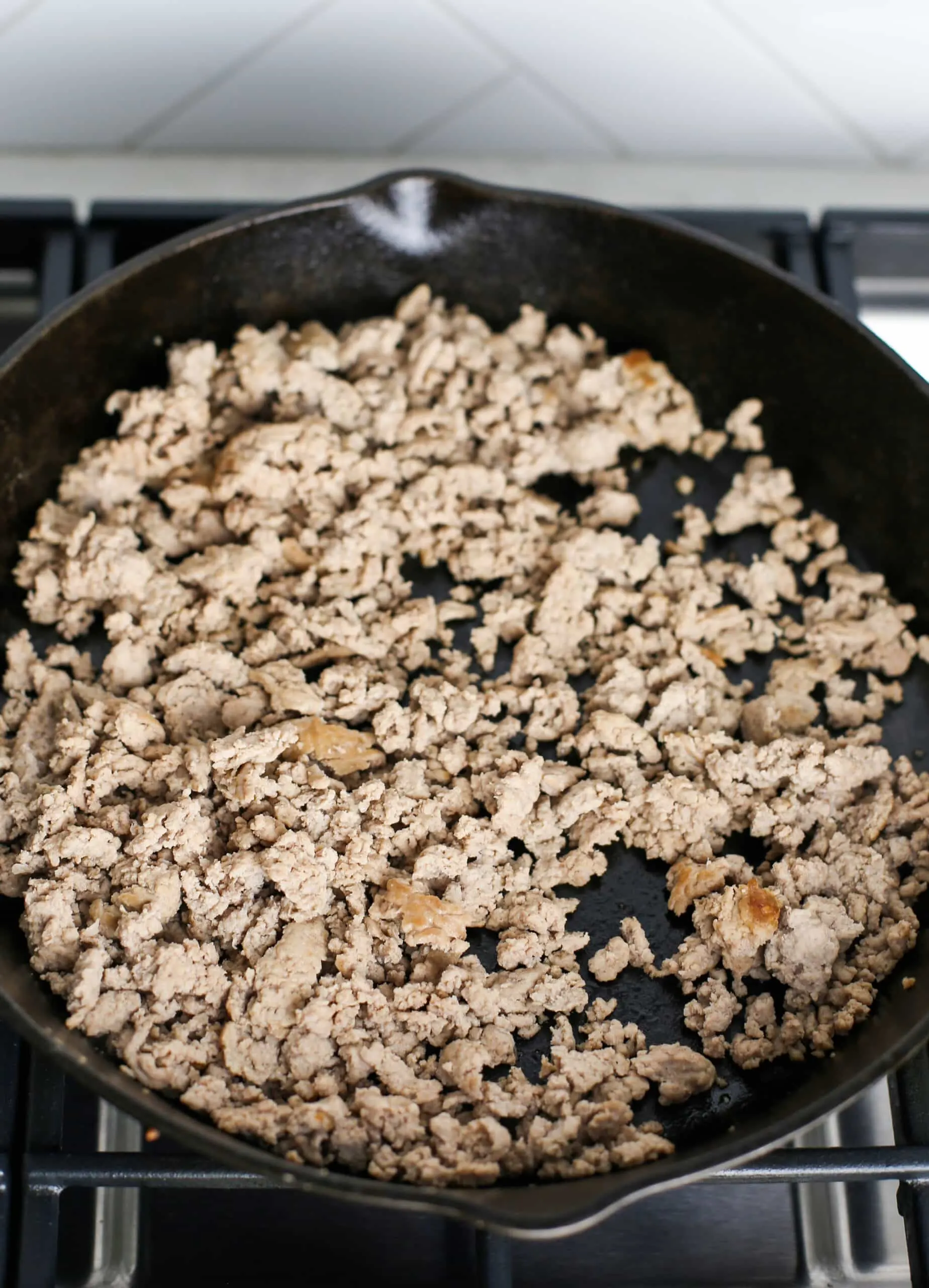 Cooked ground turkey in a large black cast iron skillet.