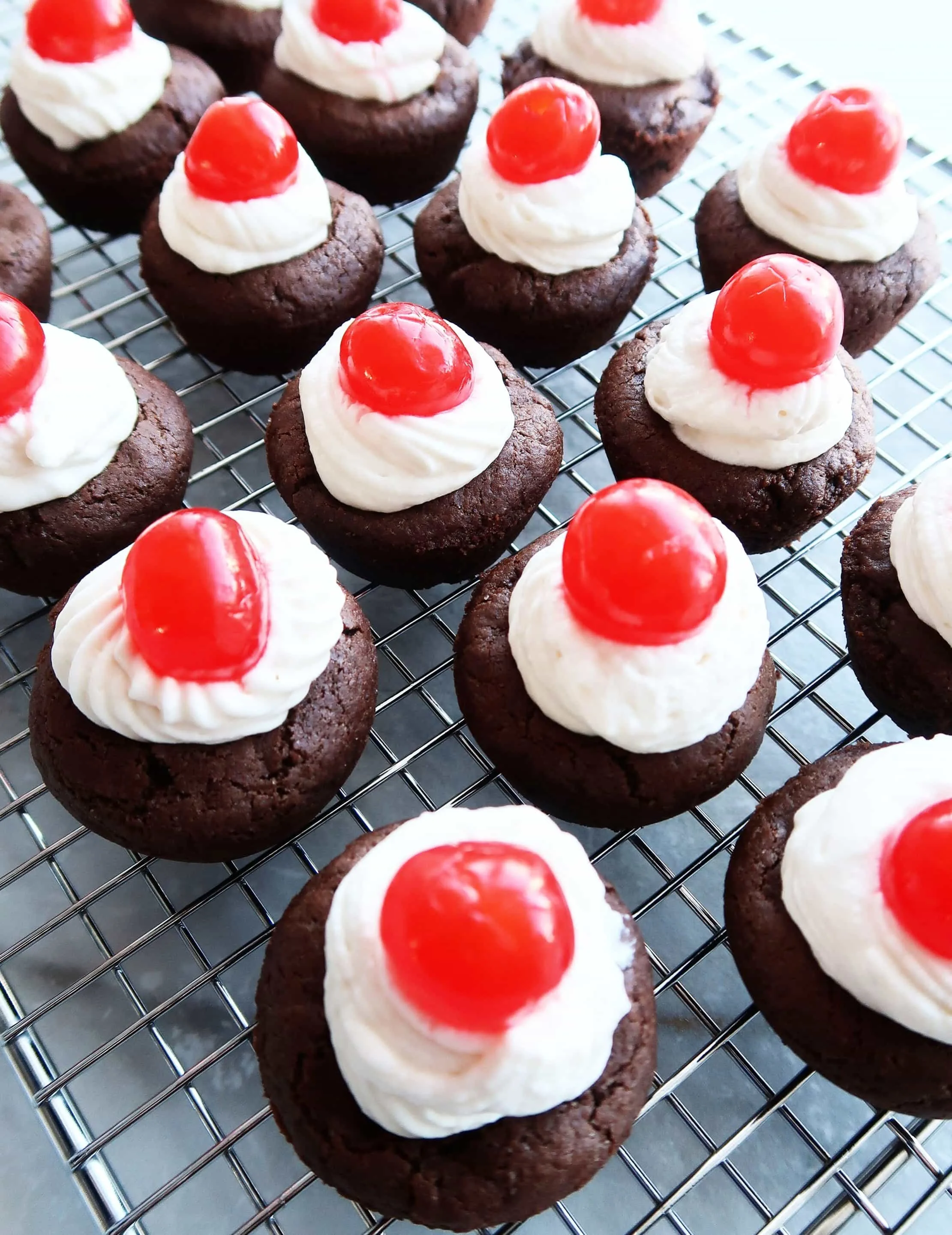 Cookie cups topped with whipped cream and cherries.