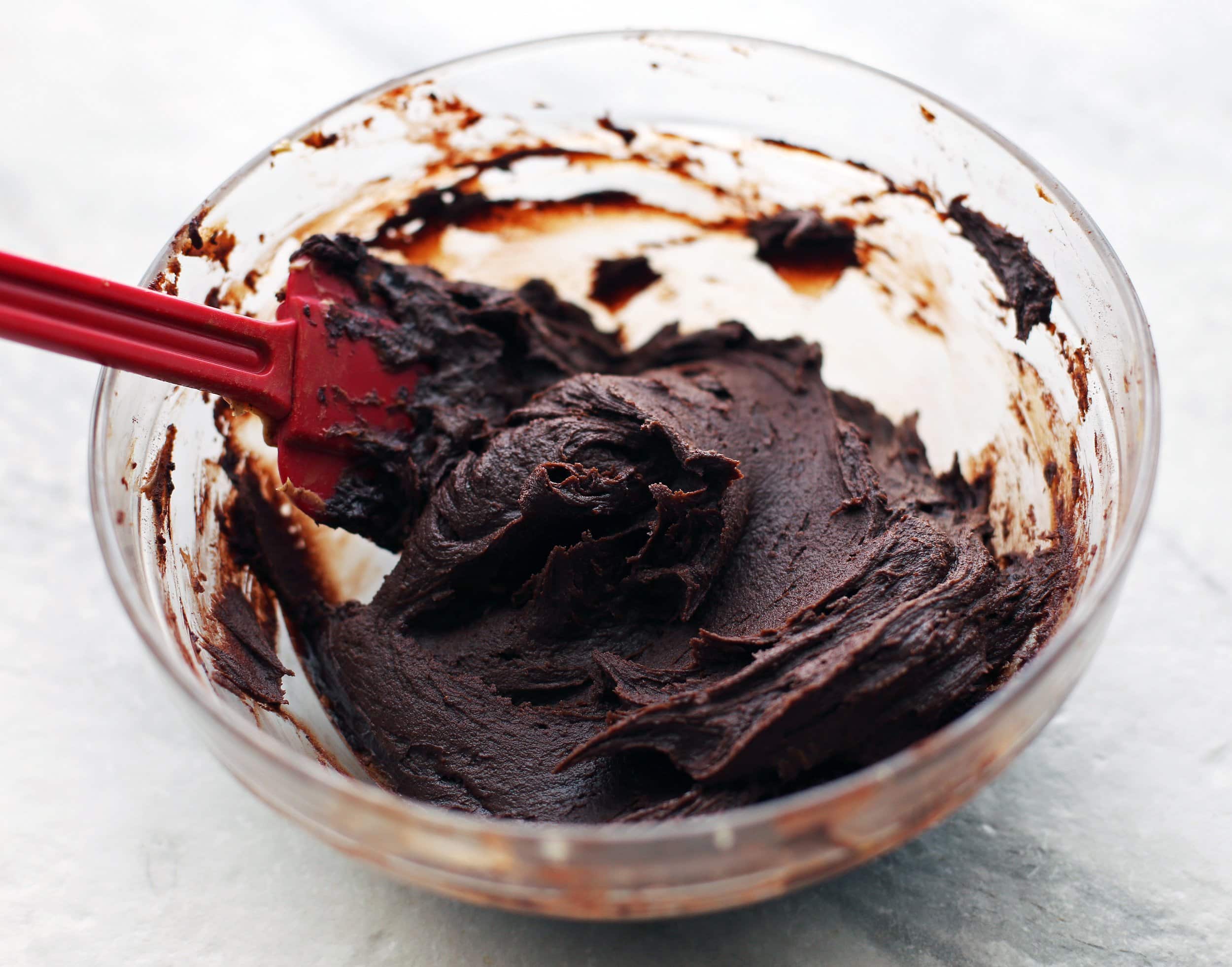 A mixture of peanut butter, cocoa powder, and maple syrup in a glass bowl.