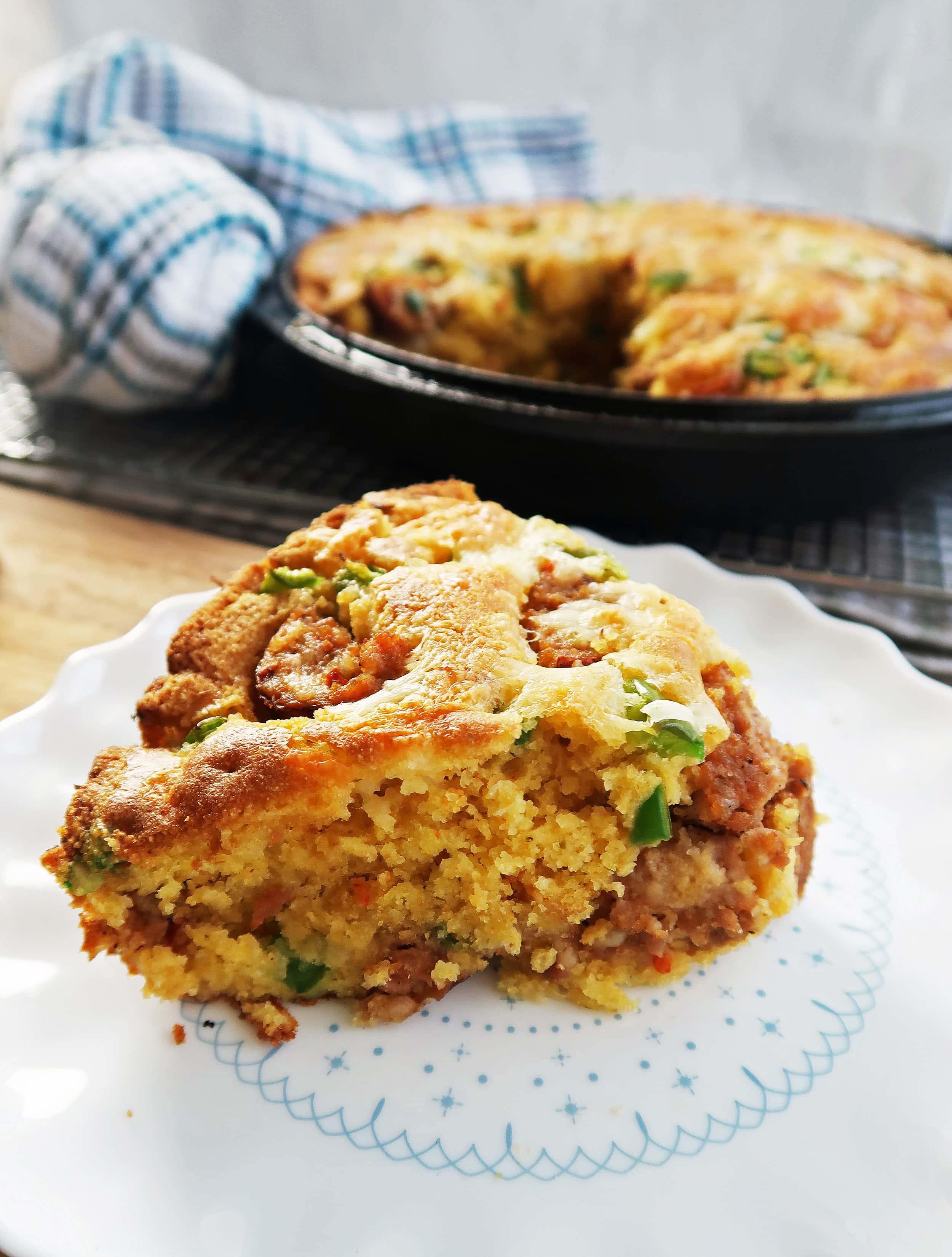 Close-up side view of a piece of tender and fluffy jalapeño maple and sausage cornbread.