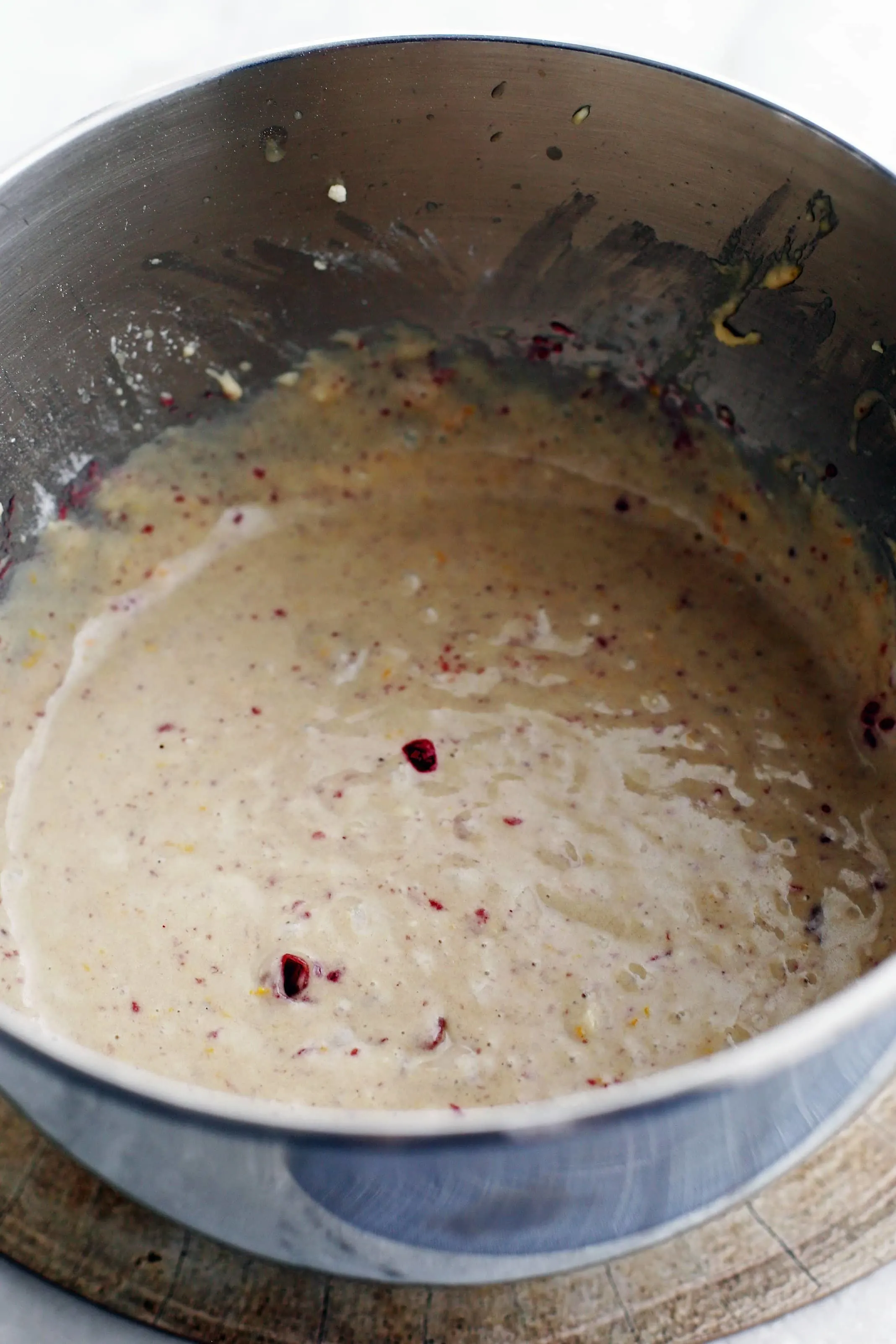 Cranberry orange muffin batter in a large metal bowl.