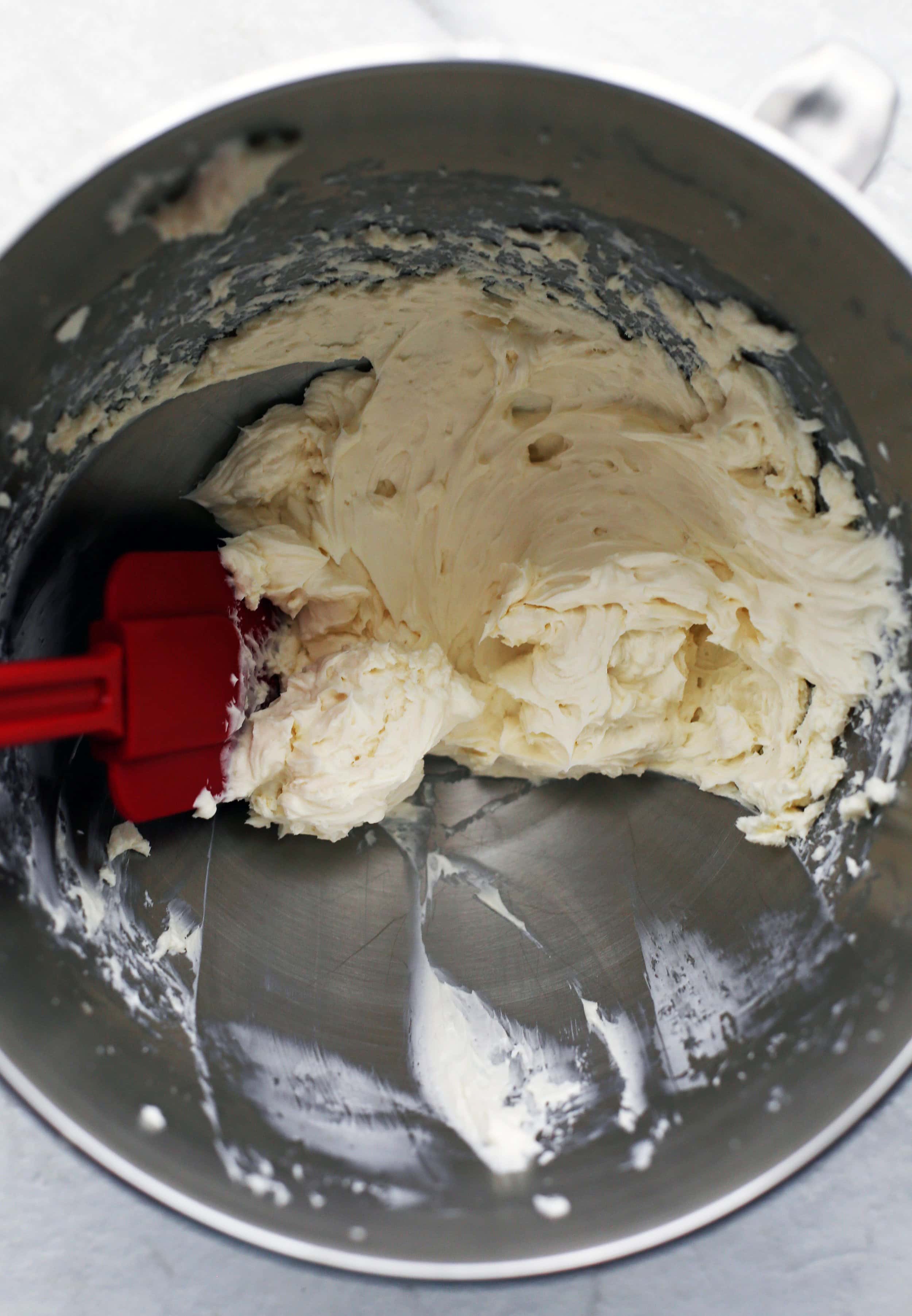 Cream cheese, vanilla extract, and sugar whisked together in a metal bowl.