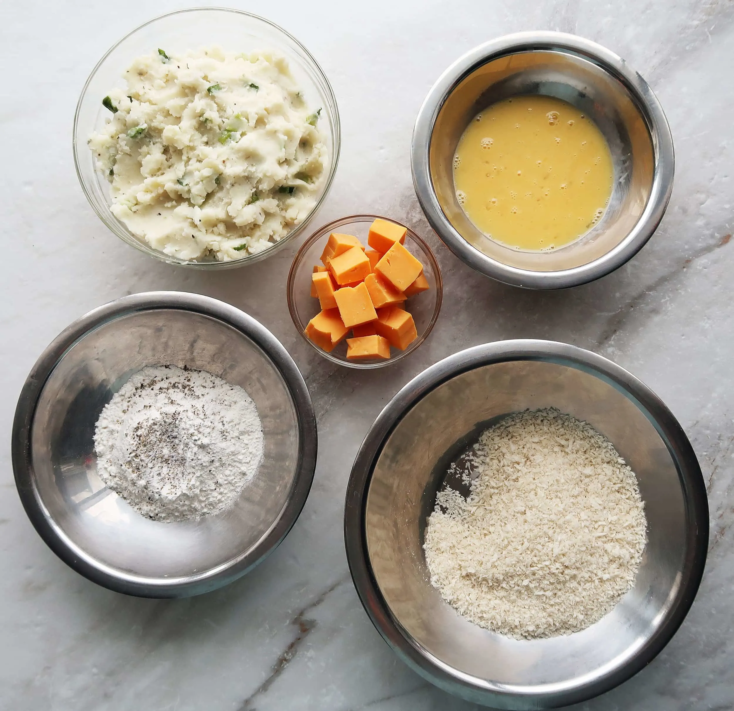 Mashed potatoes, cheese, flour, eggs, and bread crumbs.