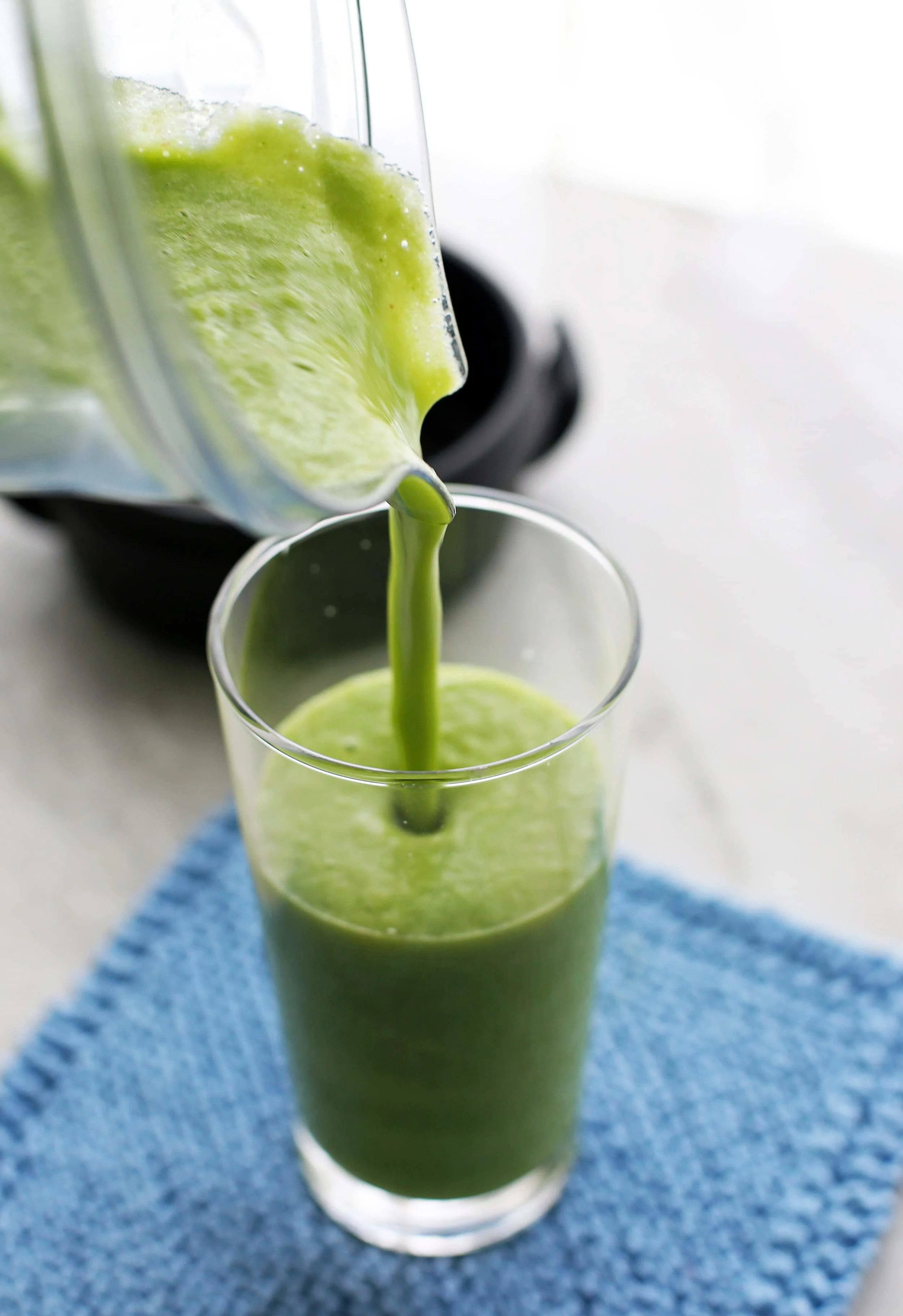 A photo of Cucumber Mint Pineapple Smoothie being poured into a tall glass.