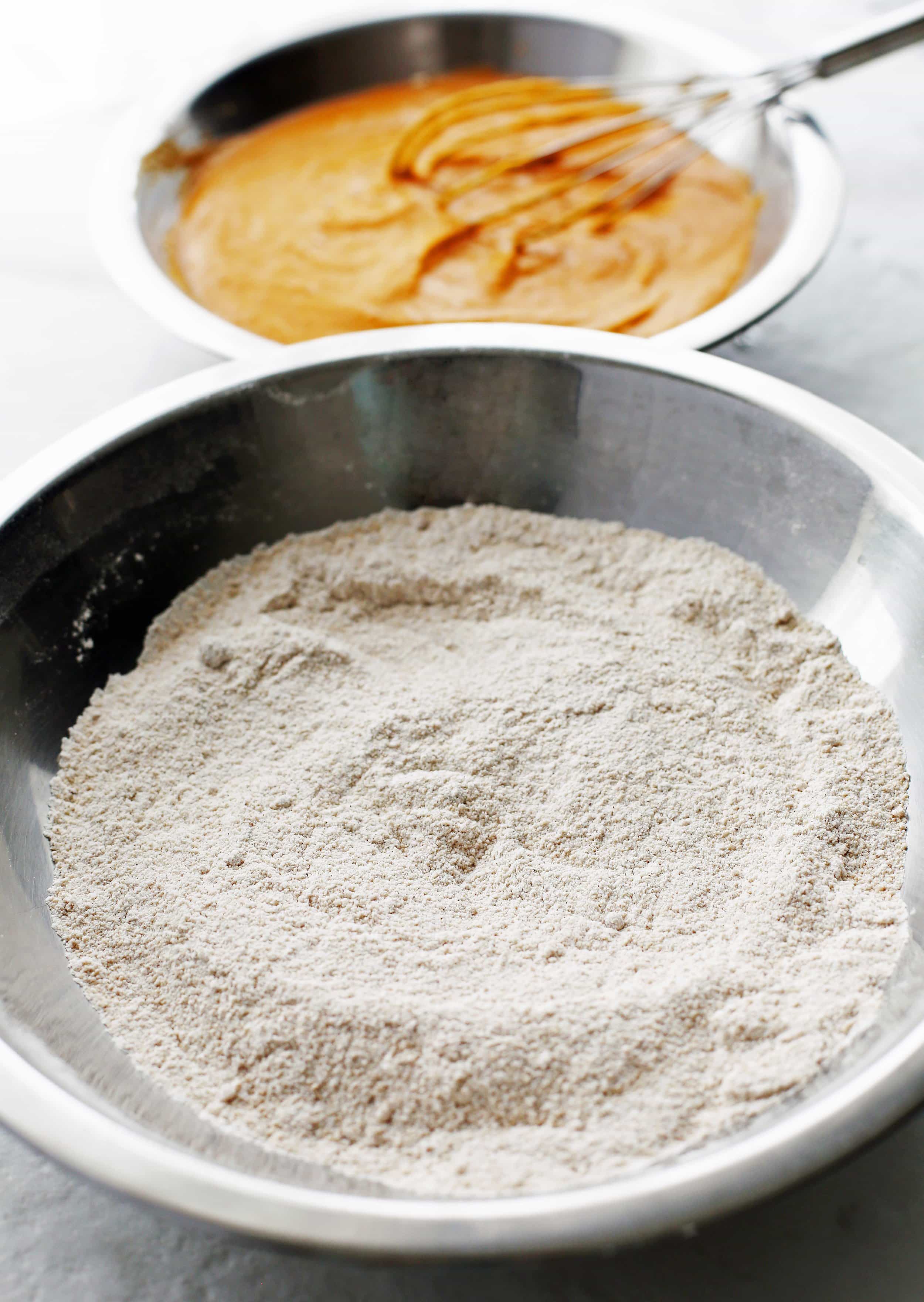 A metal bowl containing dry baking ingredients combined together.