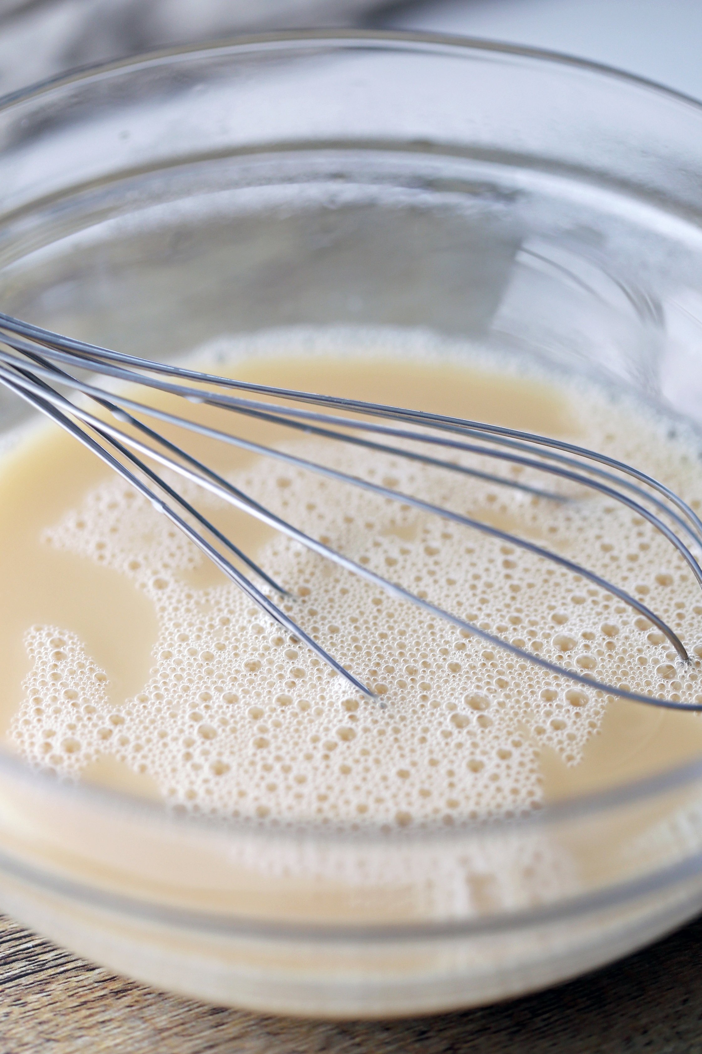 A glass bowl containing Earl Grey tea with almond milk and honey.