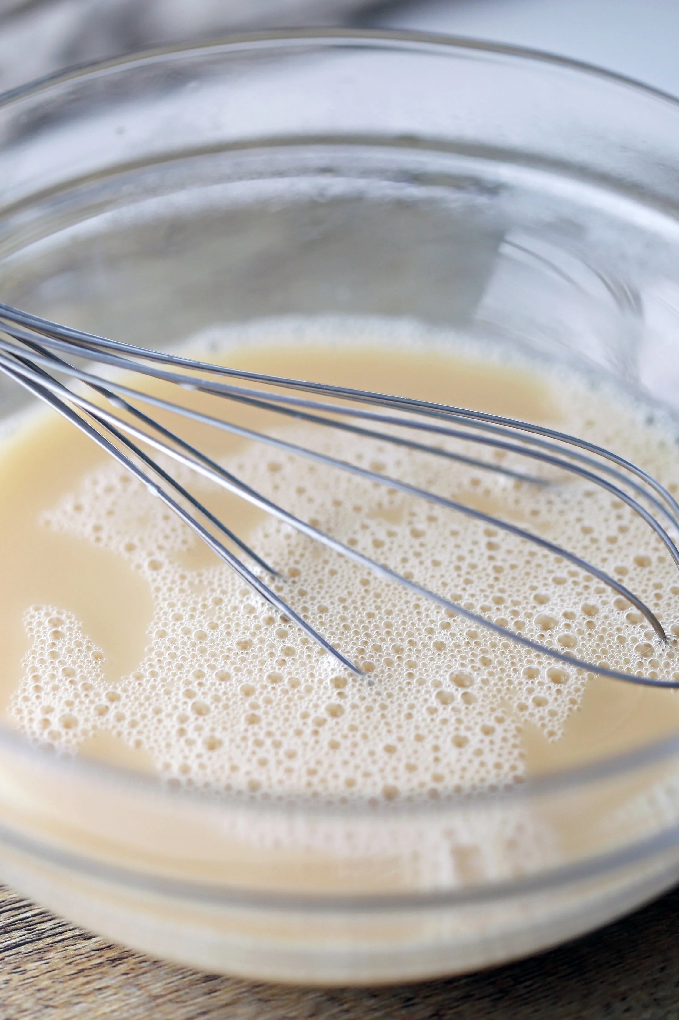 A glass bowl containing Earl Grey tea with almond milk and honey.