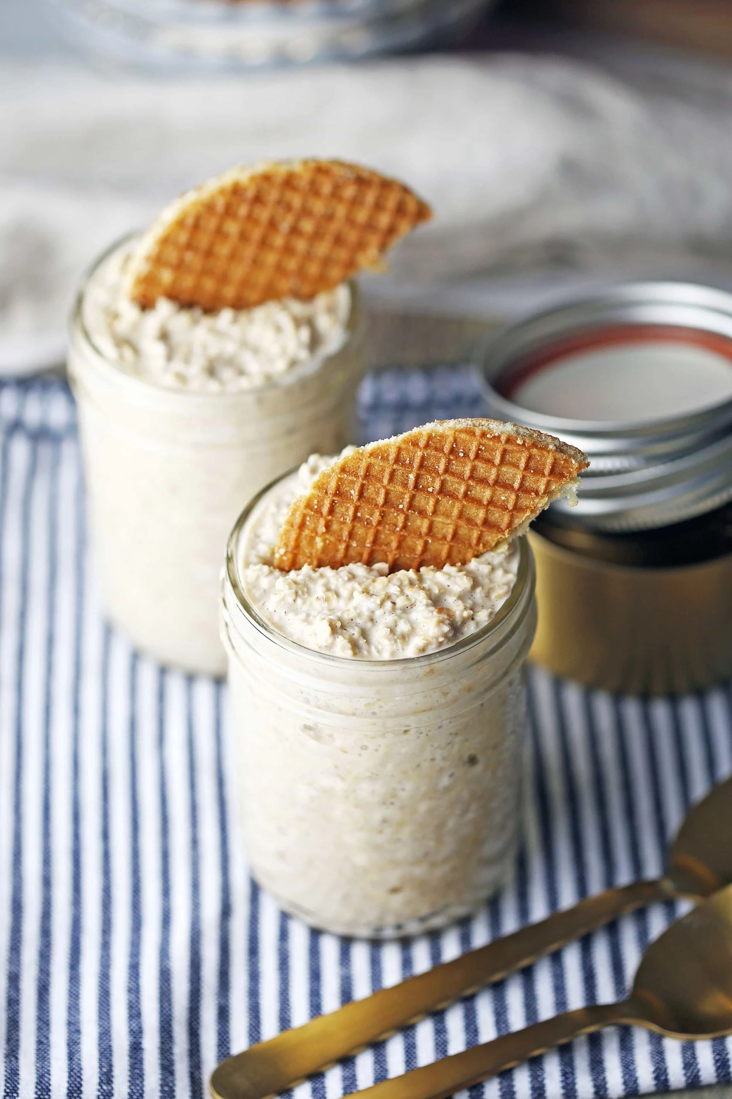 Vanilla Earl Grey Overnight Oats topped with half a stroopwafel in two glass mason jars.